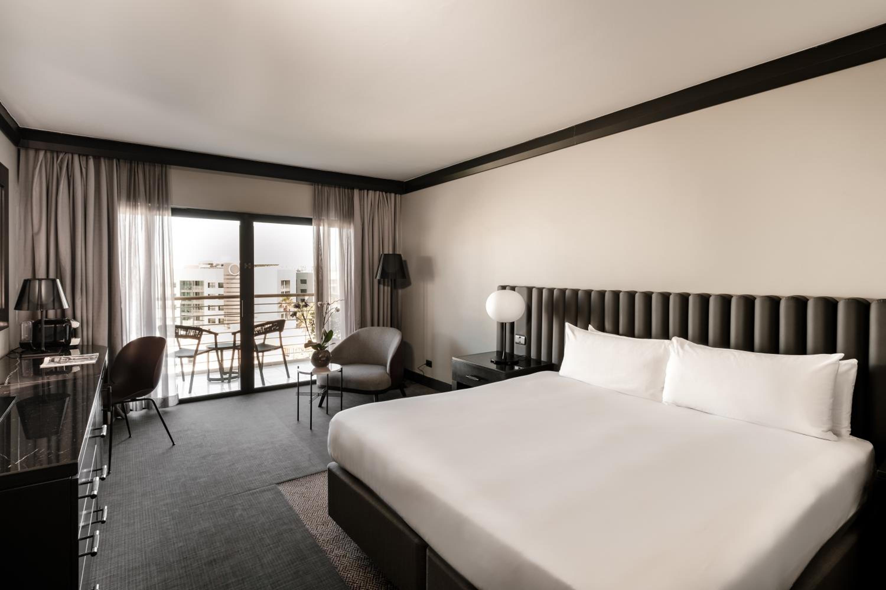 Klassisches Zimmer mit Kingsize-Bett und Blick auf den Garten sowie Zugang zur Club-Lounge.