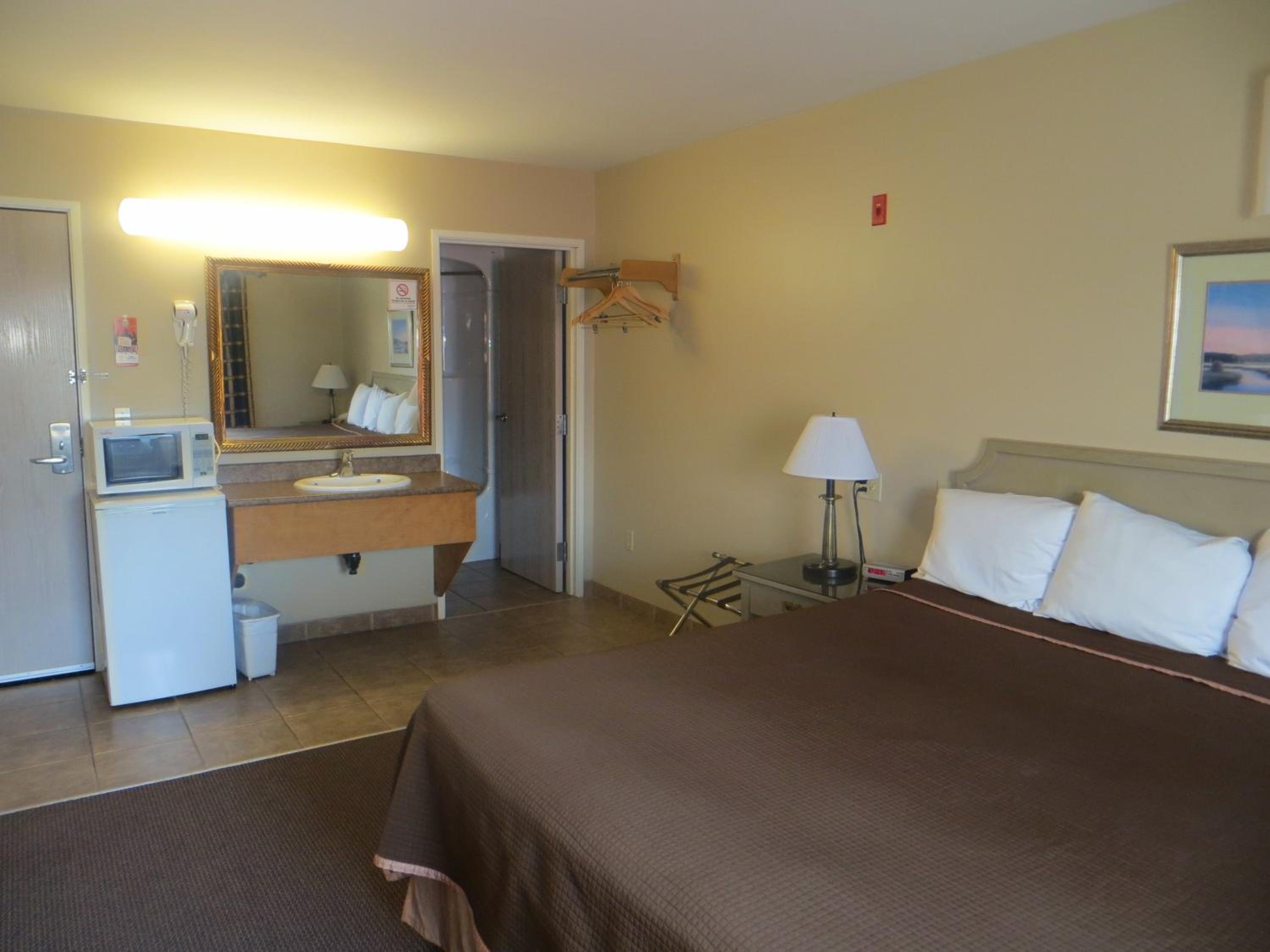 hotel room with a bed, sink, and refrigerator