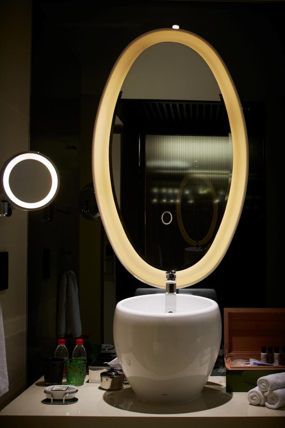 bathroom sink with a large round mirror above the sink