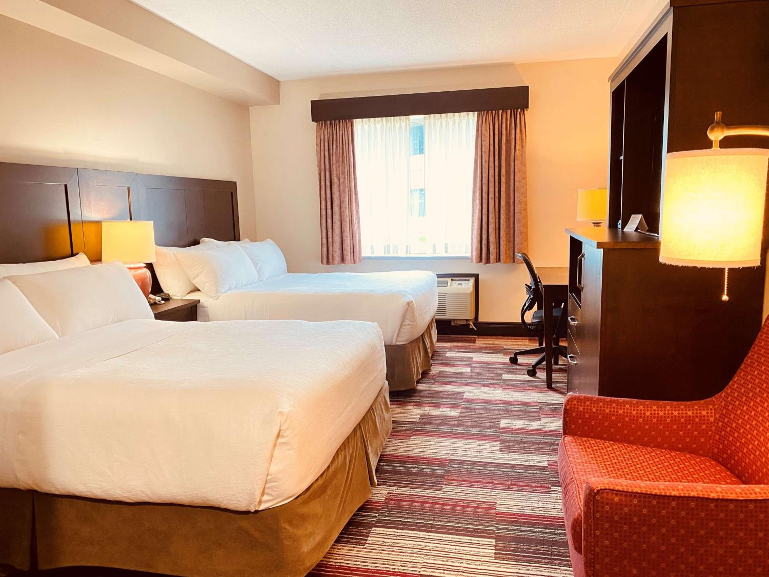 hotel room with two double beds and a red chair