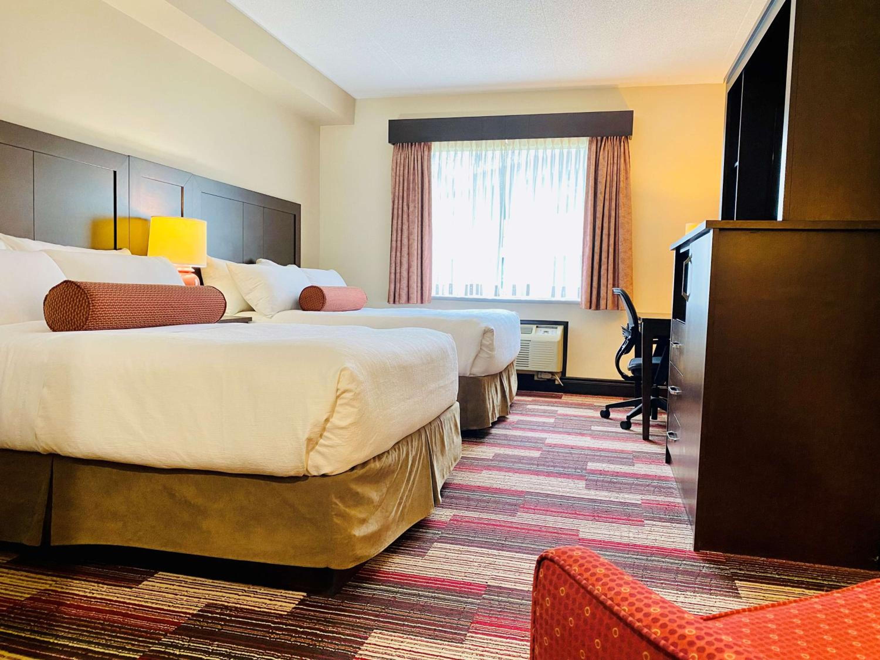 hotel room with two queen beds and a flat screen tv