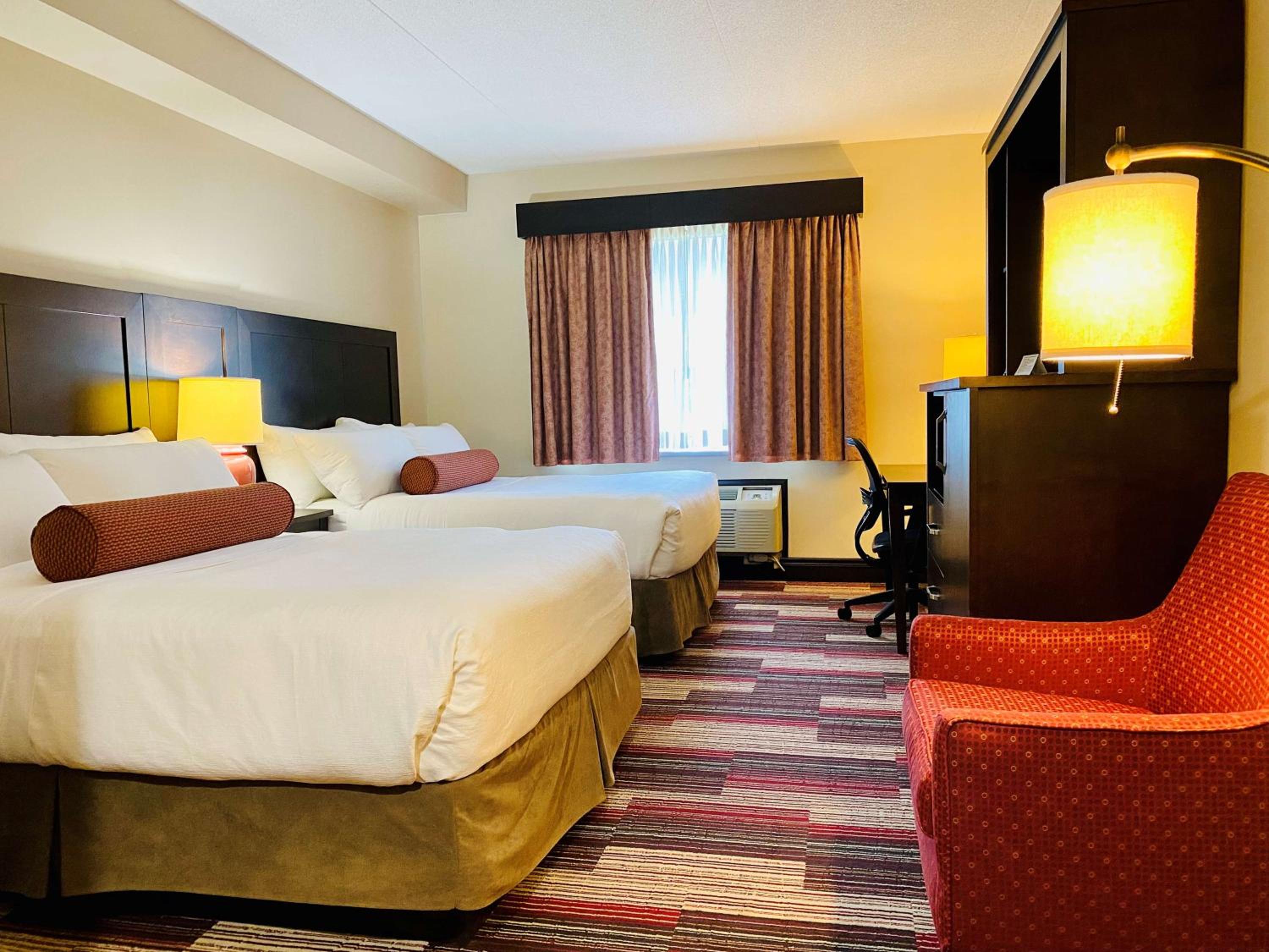 hotel room with two double beds and a red chair