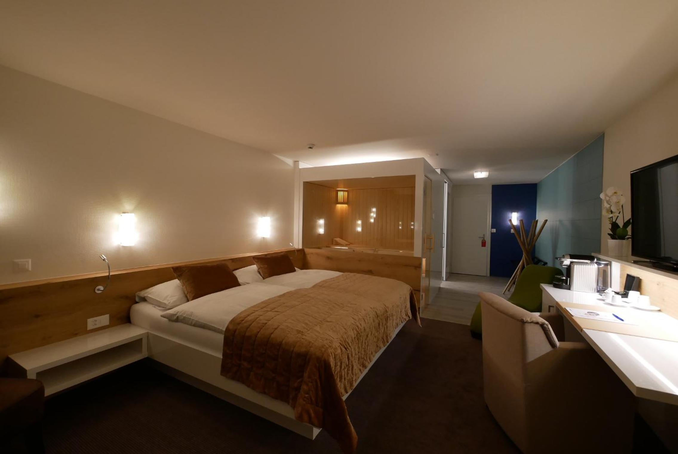 hotel room with a bed, desk, and tv