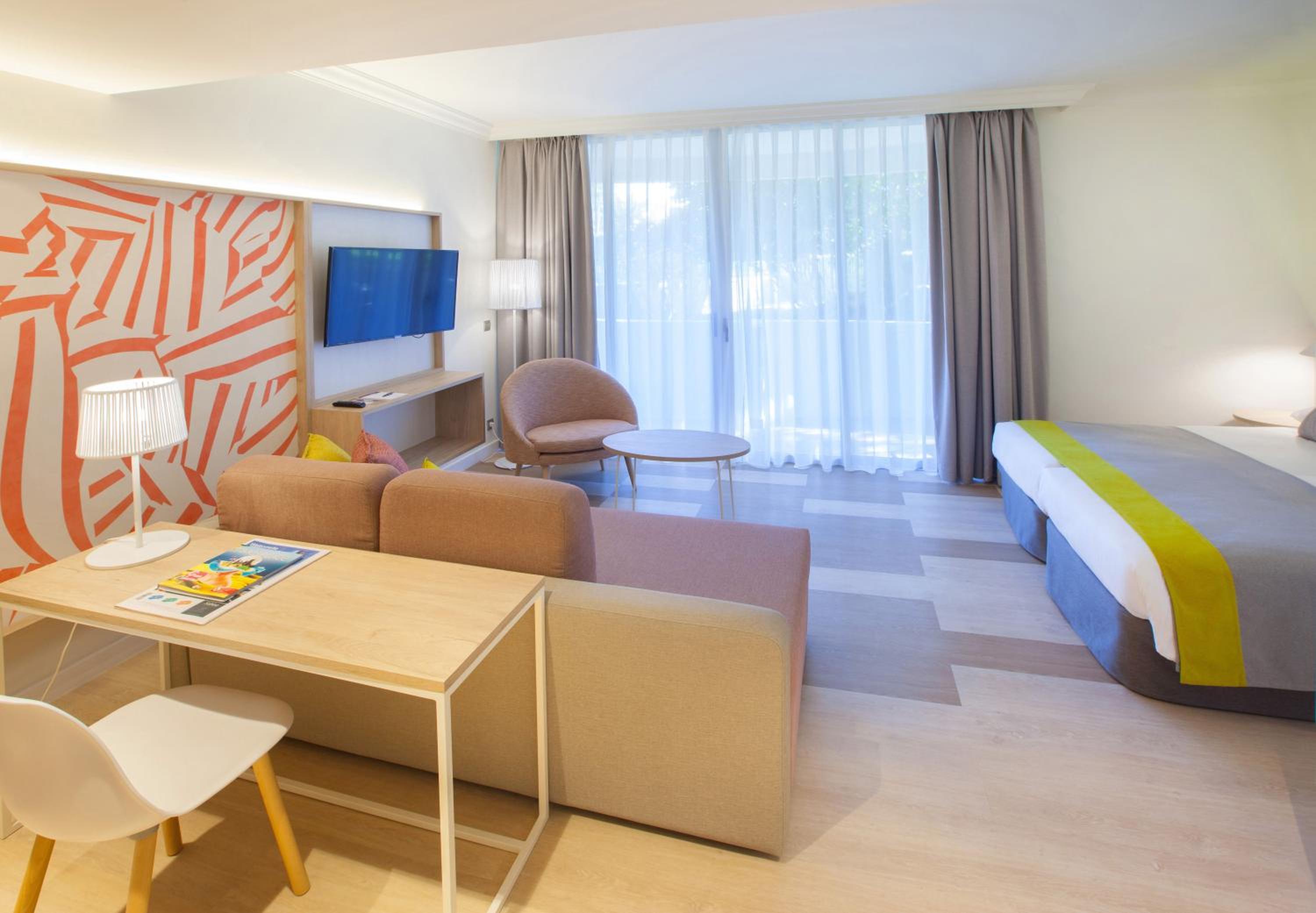 hotel room with a bed, desk, and chair