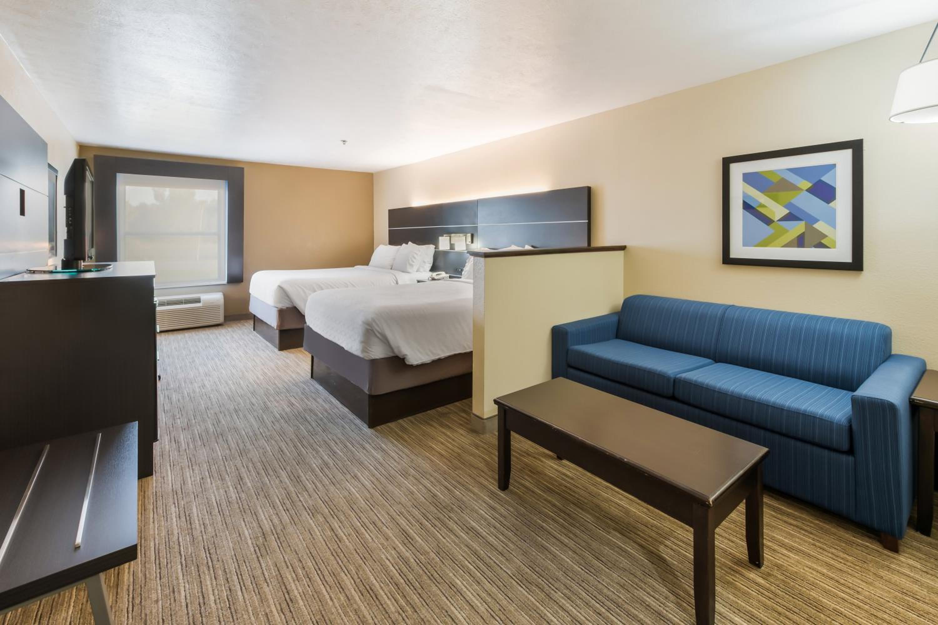hotel room with two beds and a couch in it