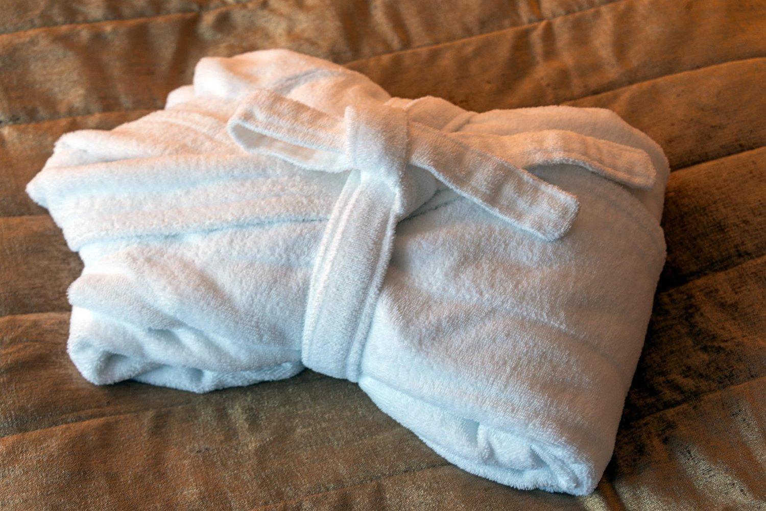 bathrobe wrapped in white towels on a bed