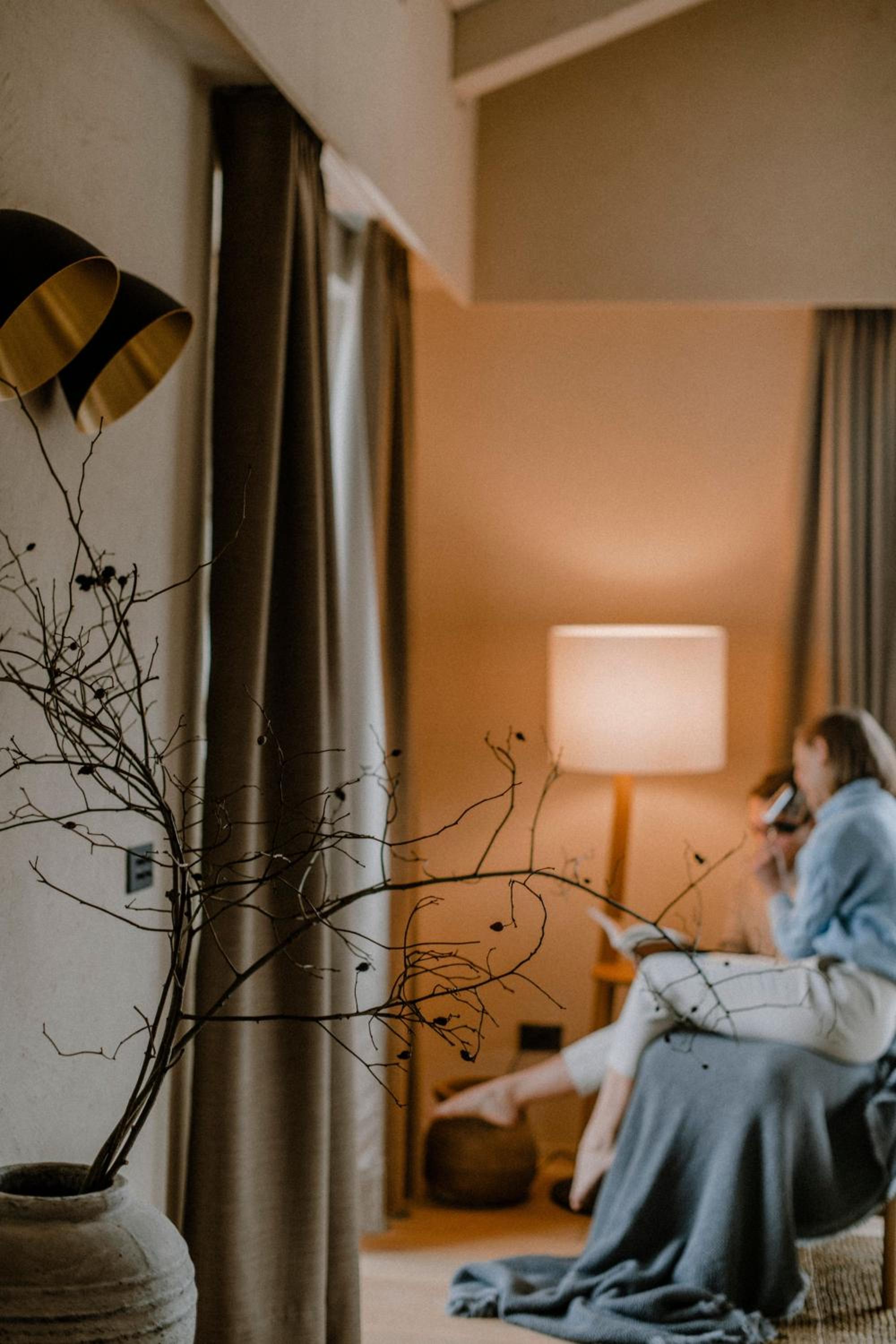 photo of a woman sitting on a couch in a hotel room