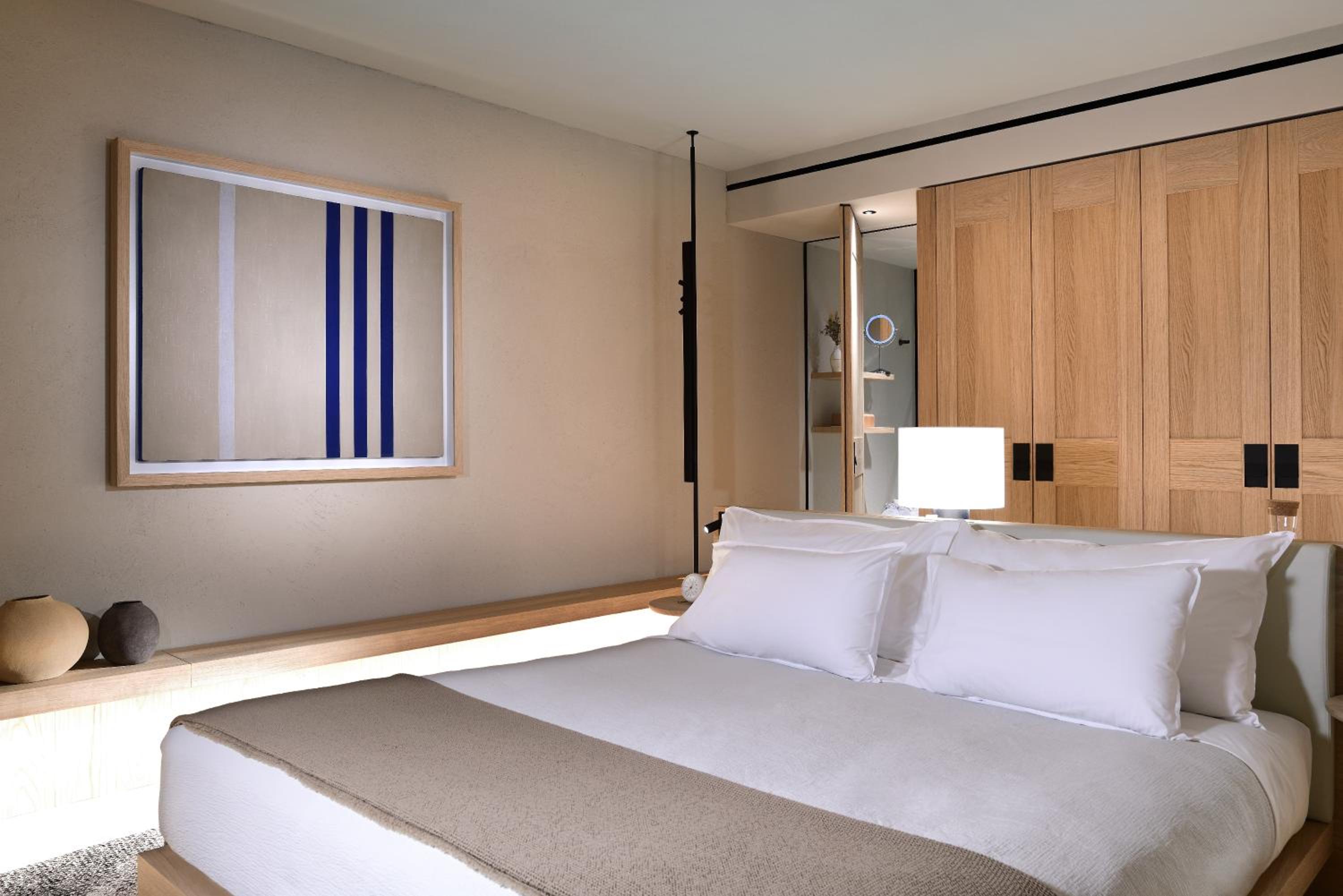 bedroom with a white bed and wood paneled walls
