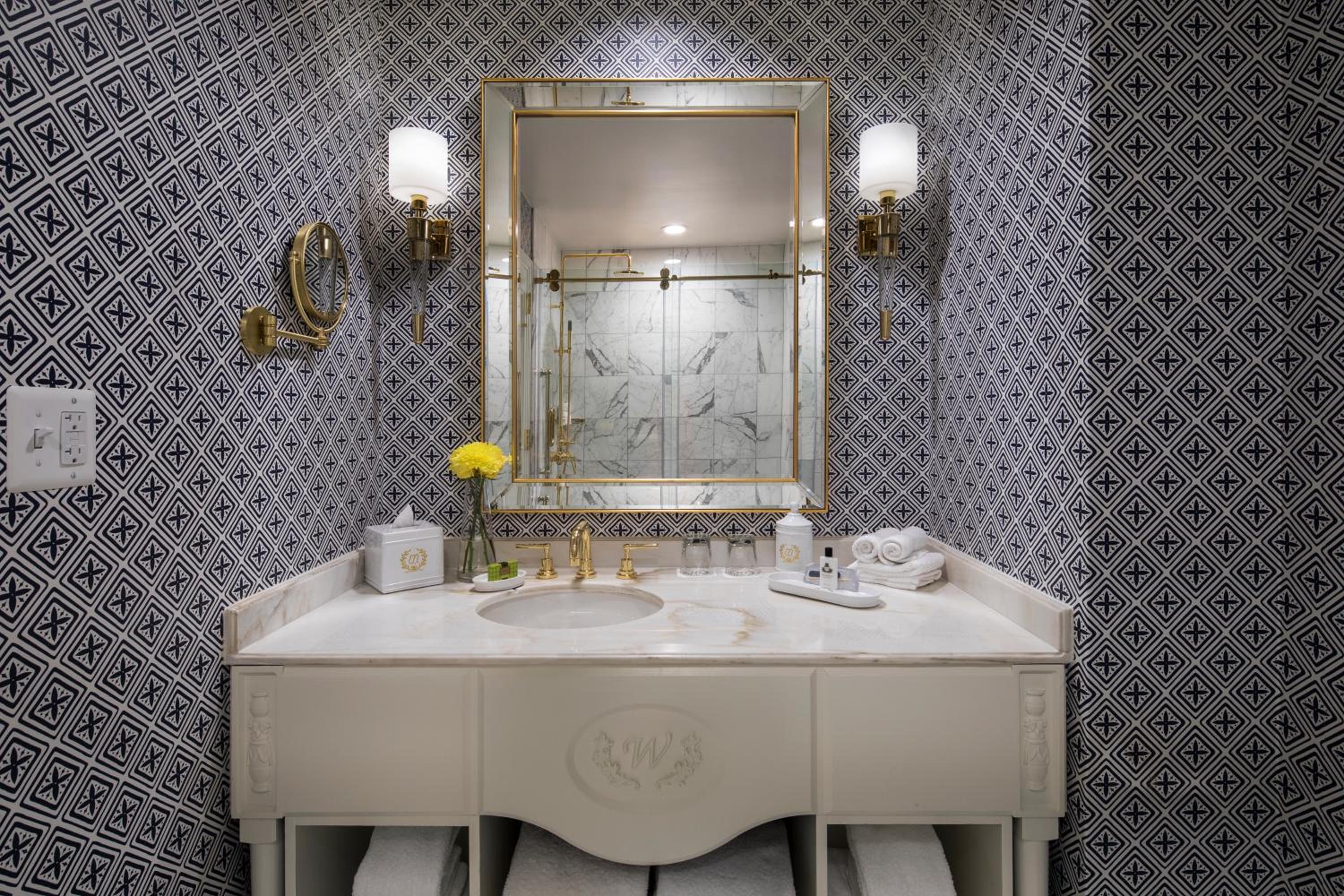 bathroom with a white sink and a gold framed mirror