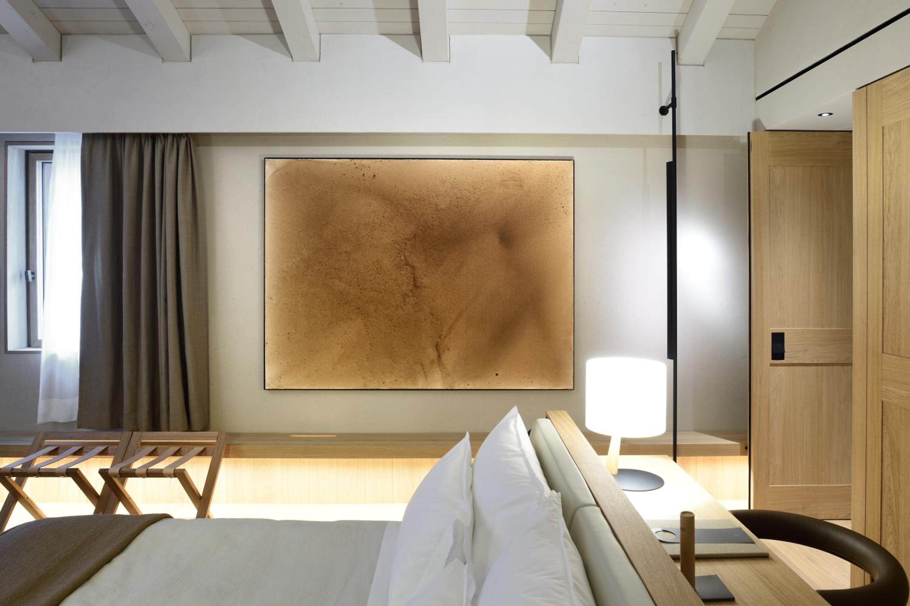 piece of art hanging on the wall above the bed