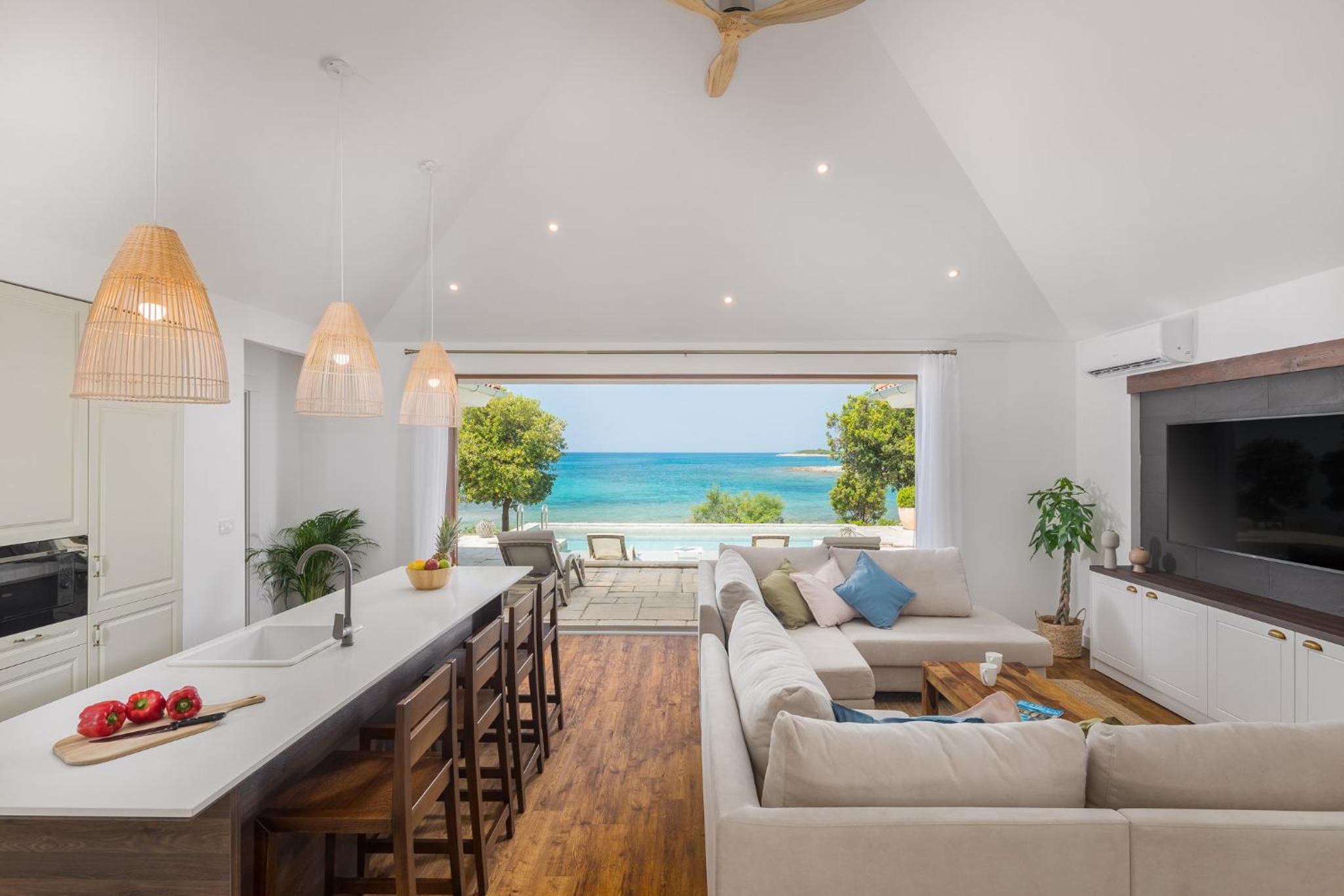 Villa frente a la playa con piscina privada y vista al mar.