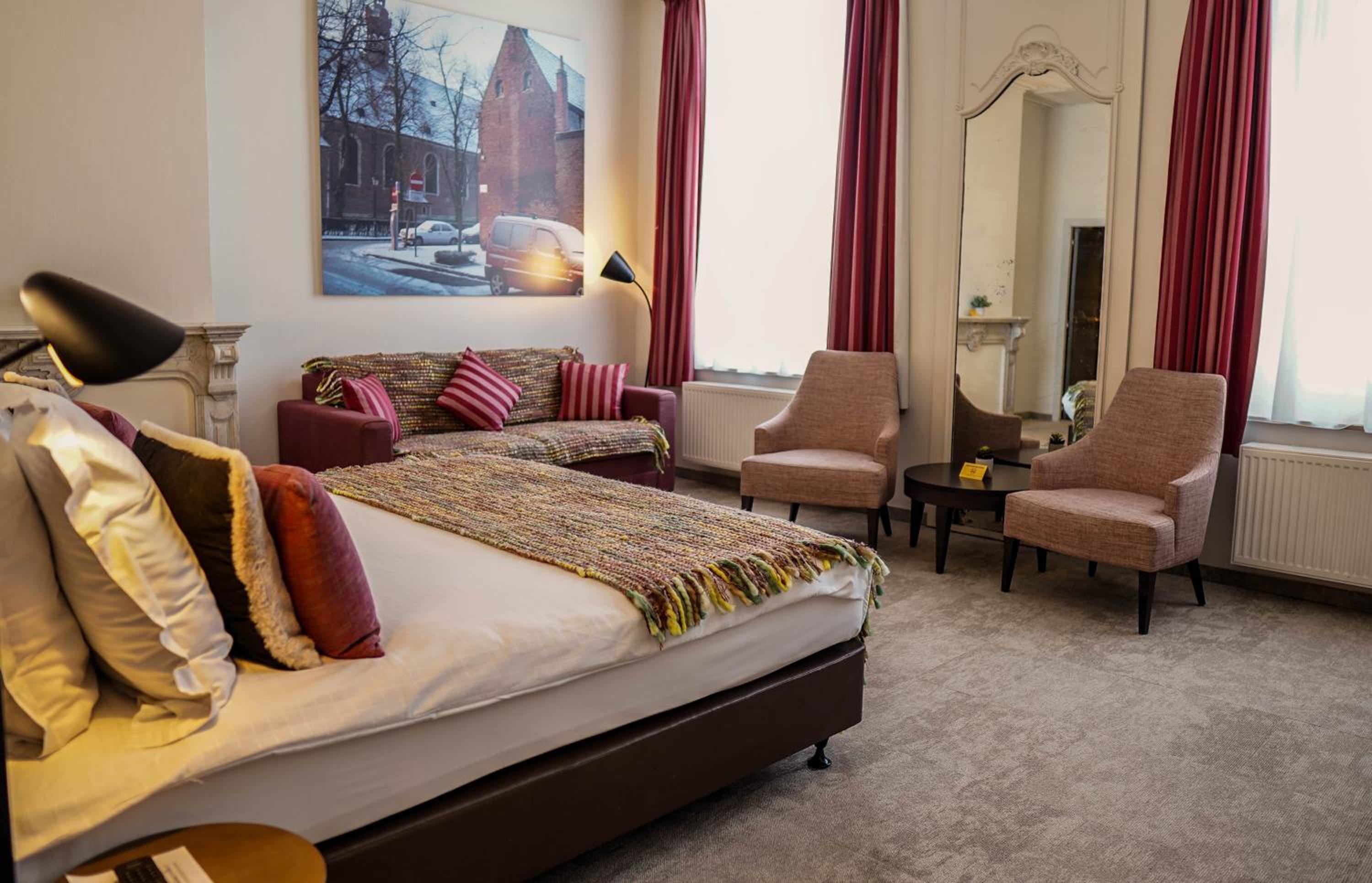 hotel room with a bed, chairs and a couch