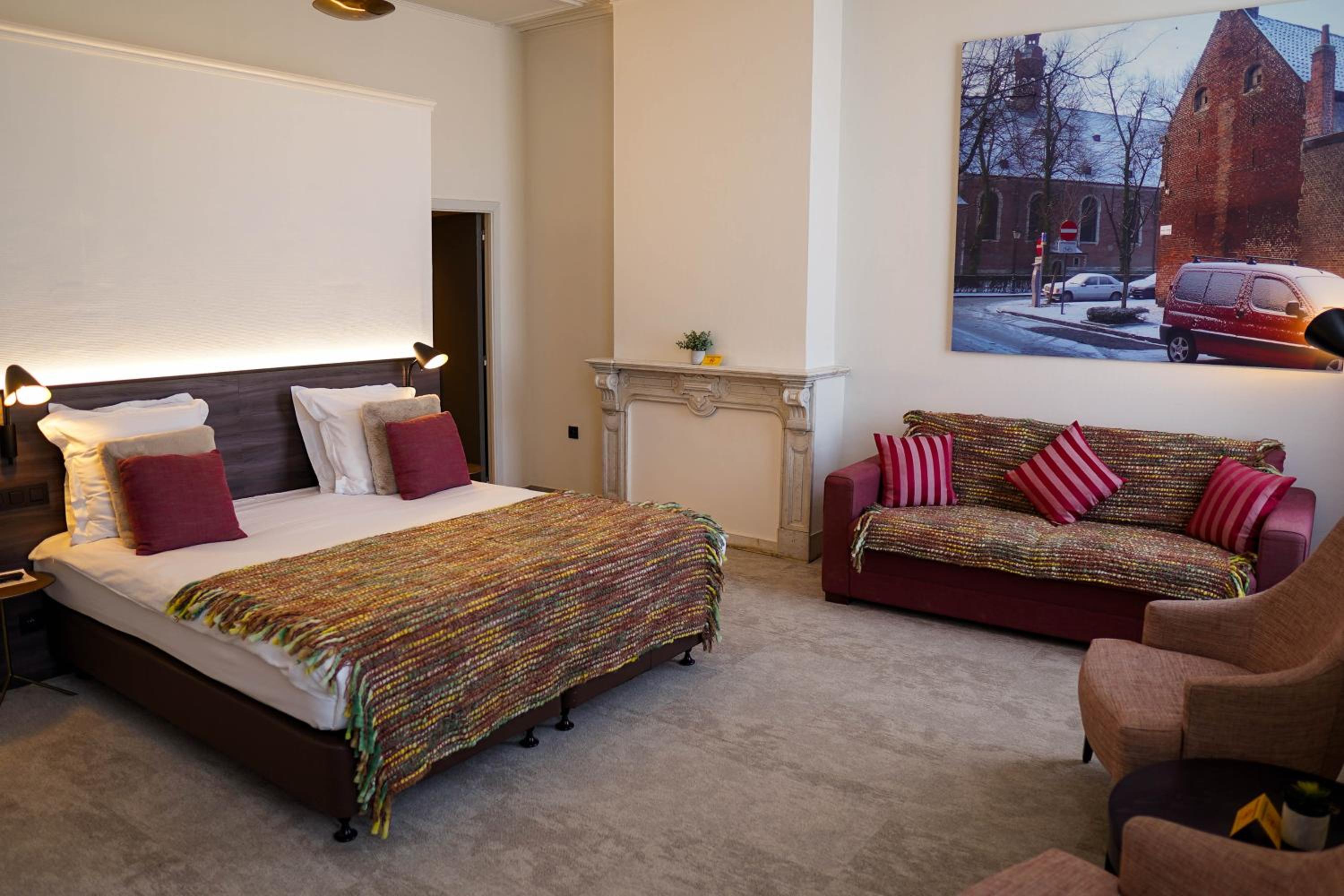 hotel room with a bed, couch, and chair