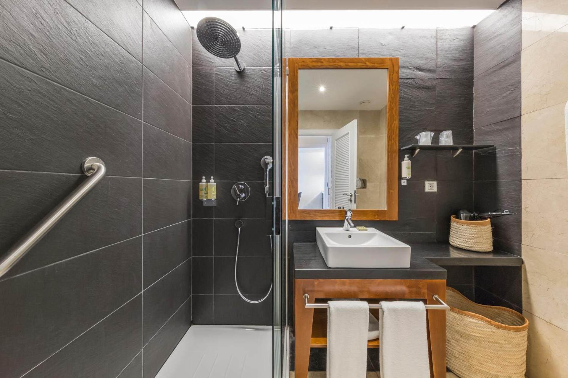 bathroom with a shower, sink, and towel rack
