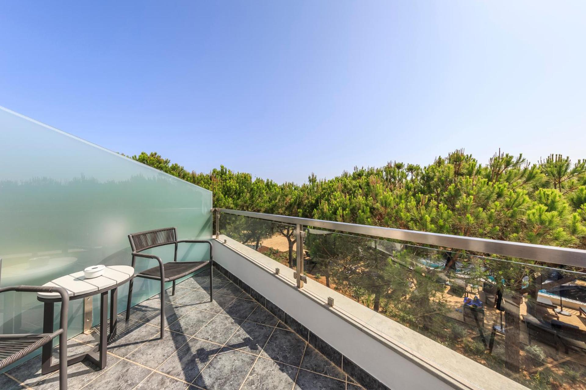 balcony with a table and two chairs overlooking the ocean