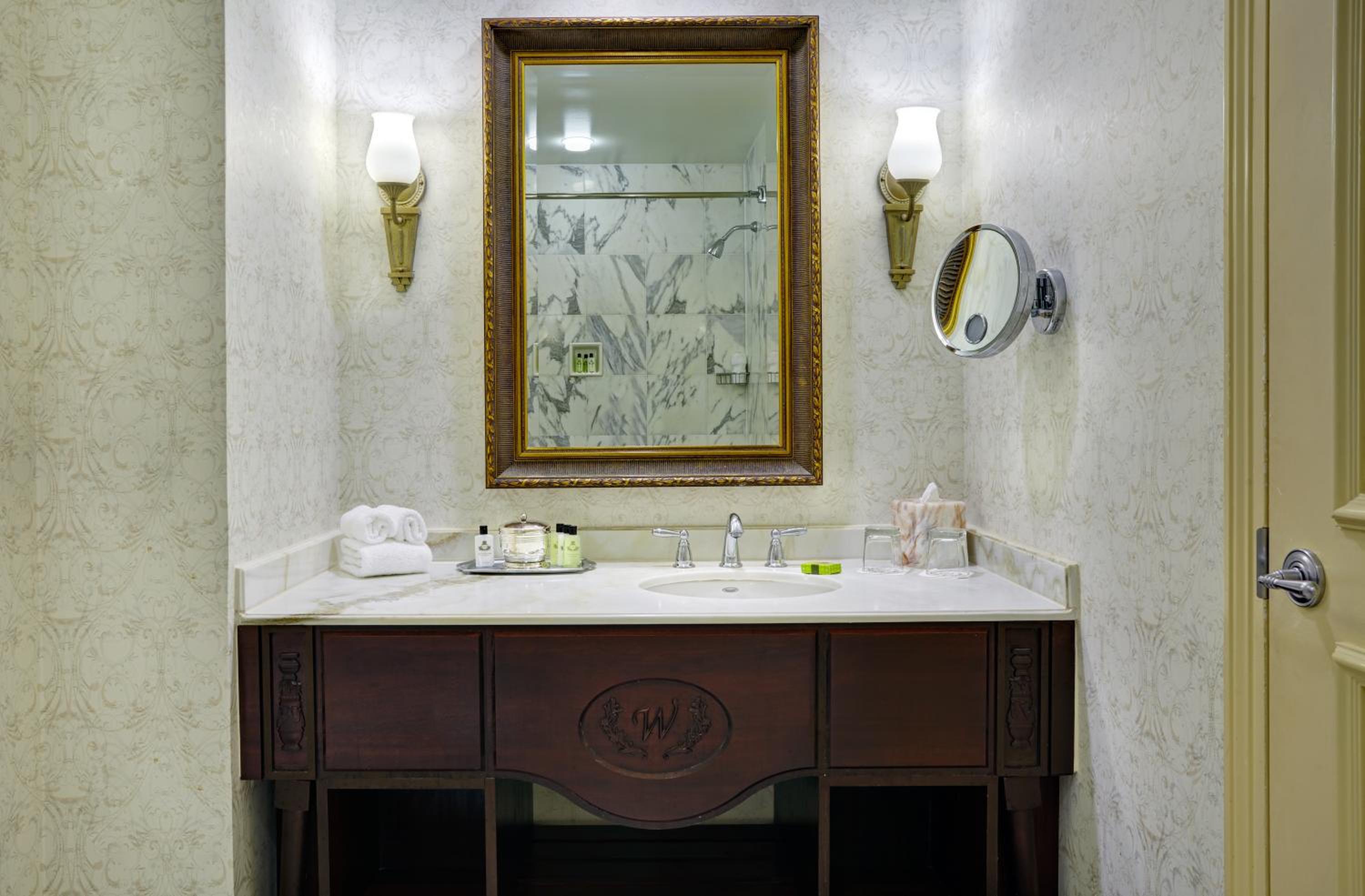 bathroom with a marble counter top and a large mirror