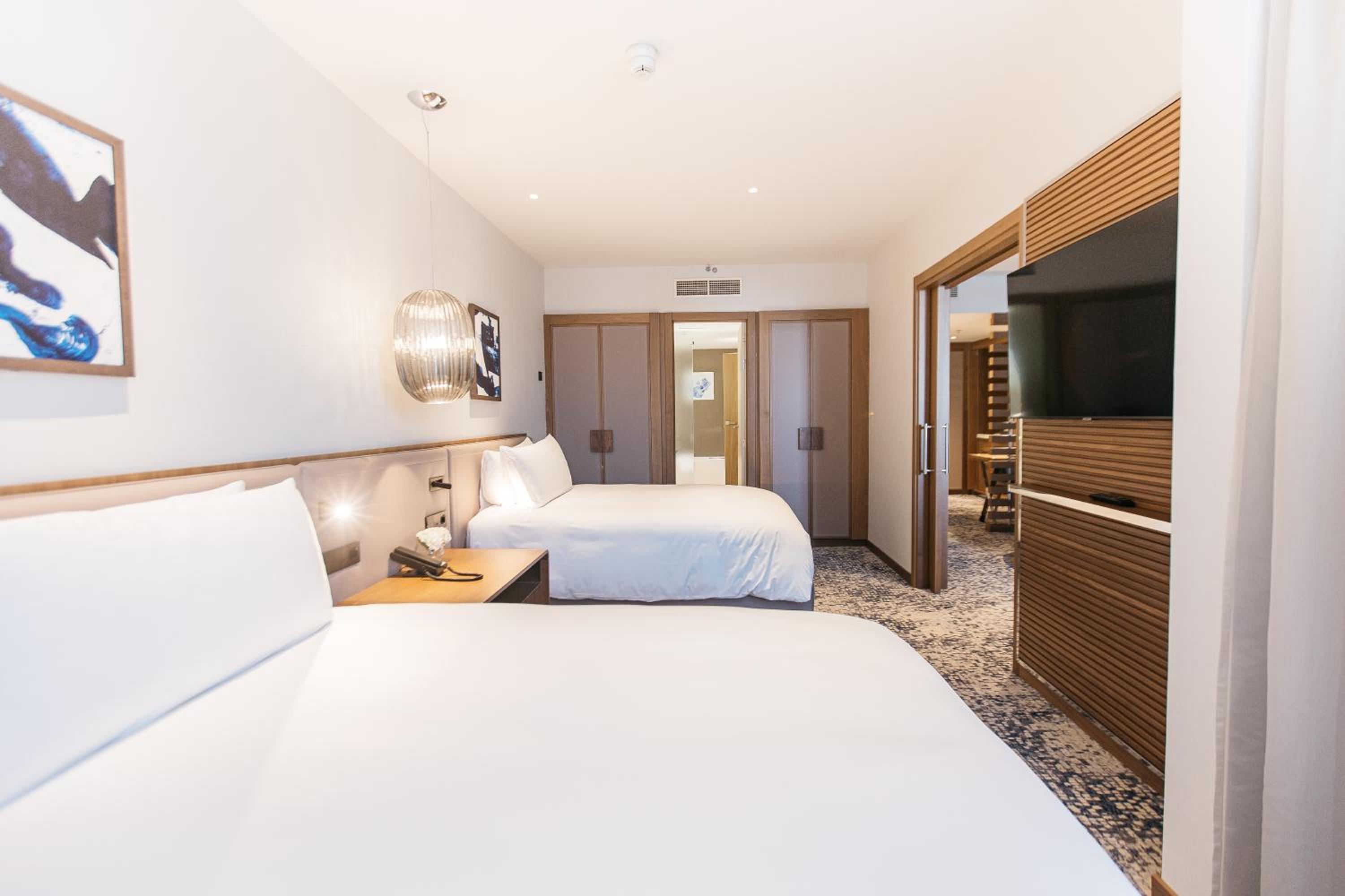 Suite de un dormitorio con dos camas y sofá cama con balcón