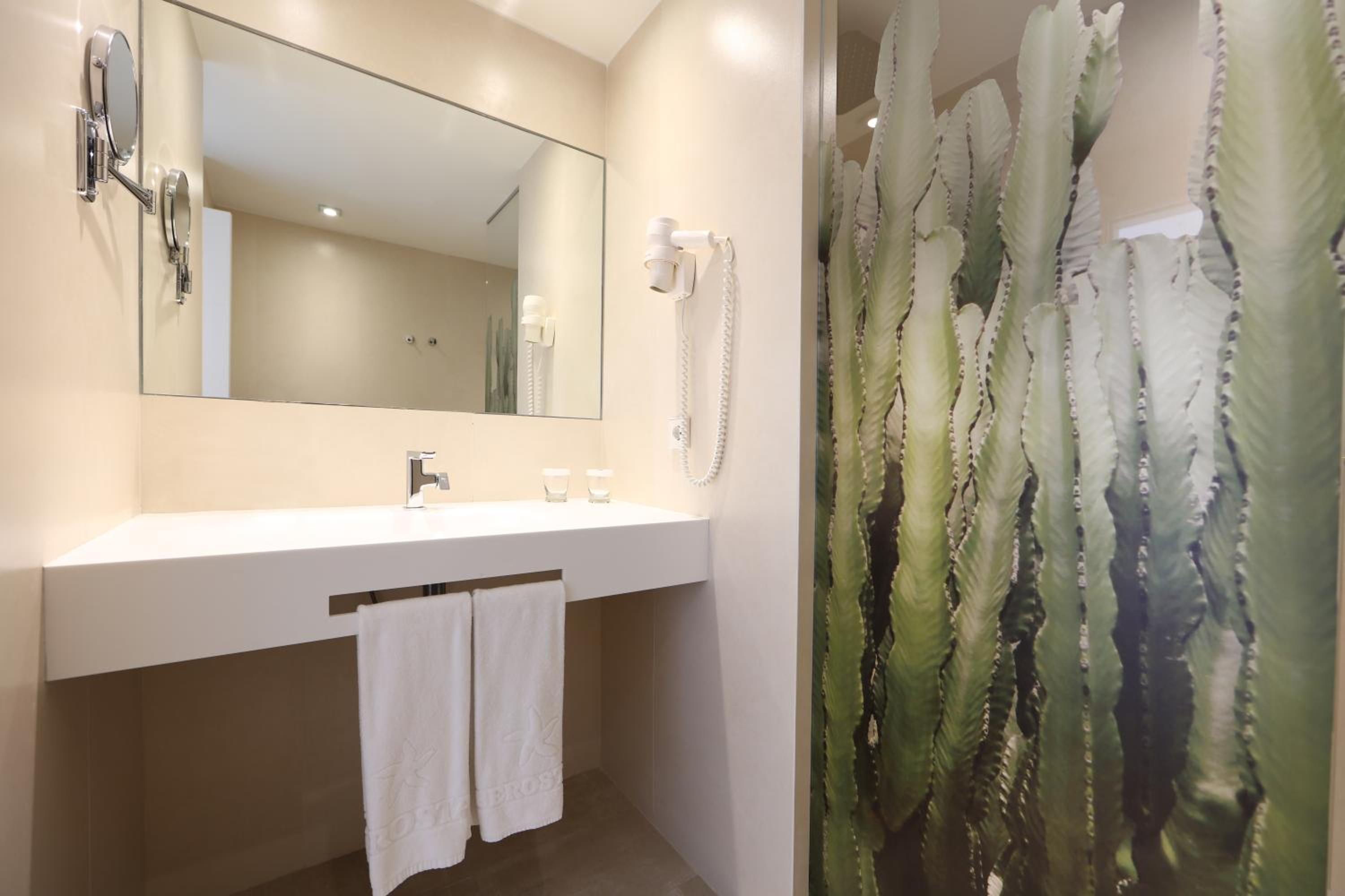 bathroom with a cactus shower curtain next to the sink