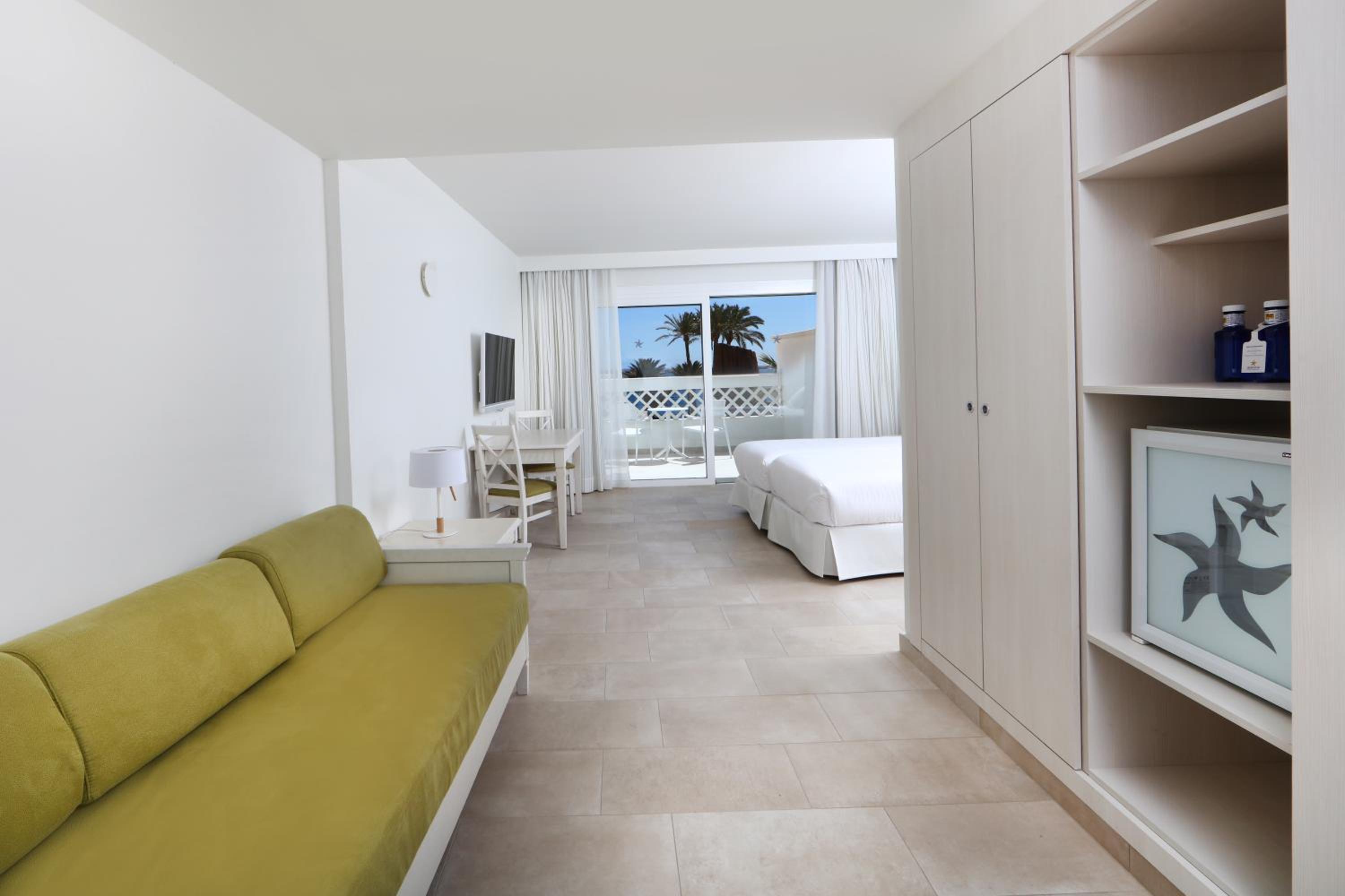 hotel room with two beds and a couch in it