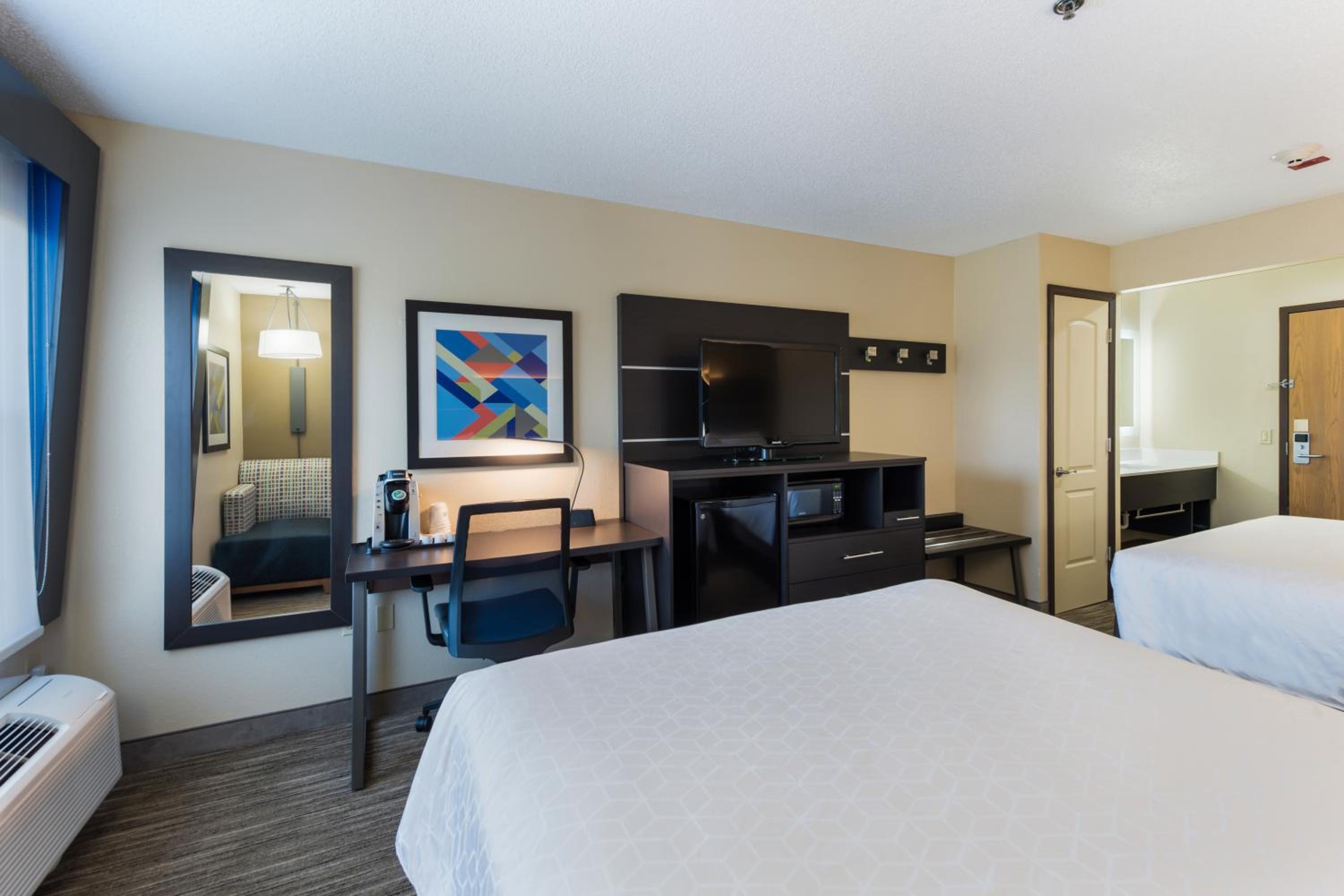 hotel room with two beds and a flat screen tv