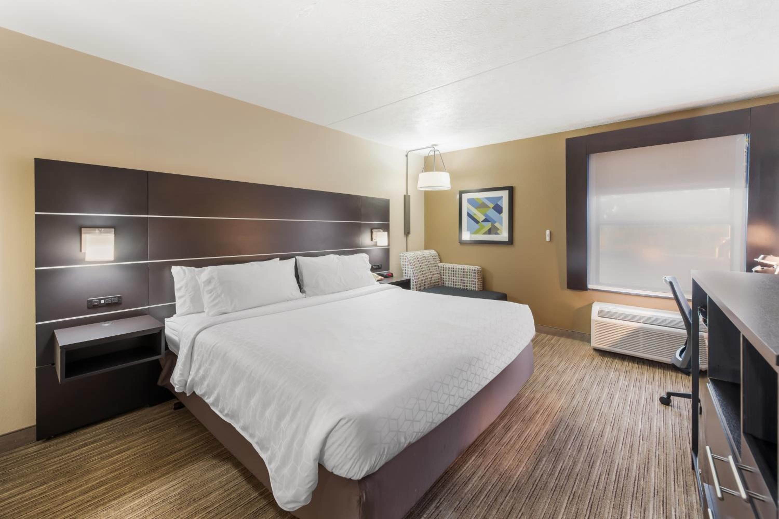 hotel room with a bed, desk, and television