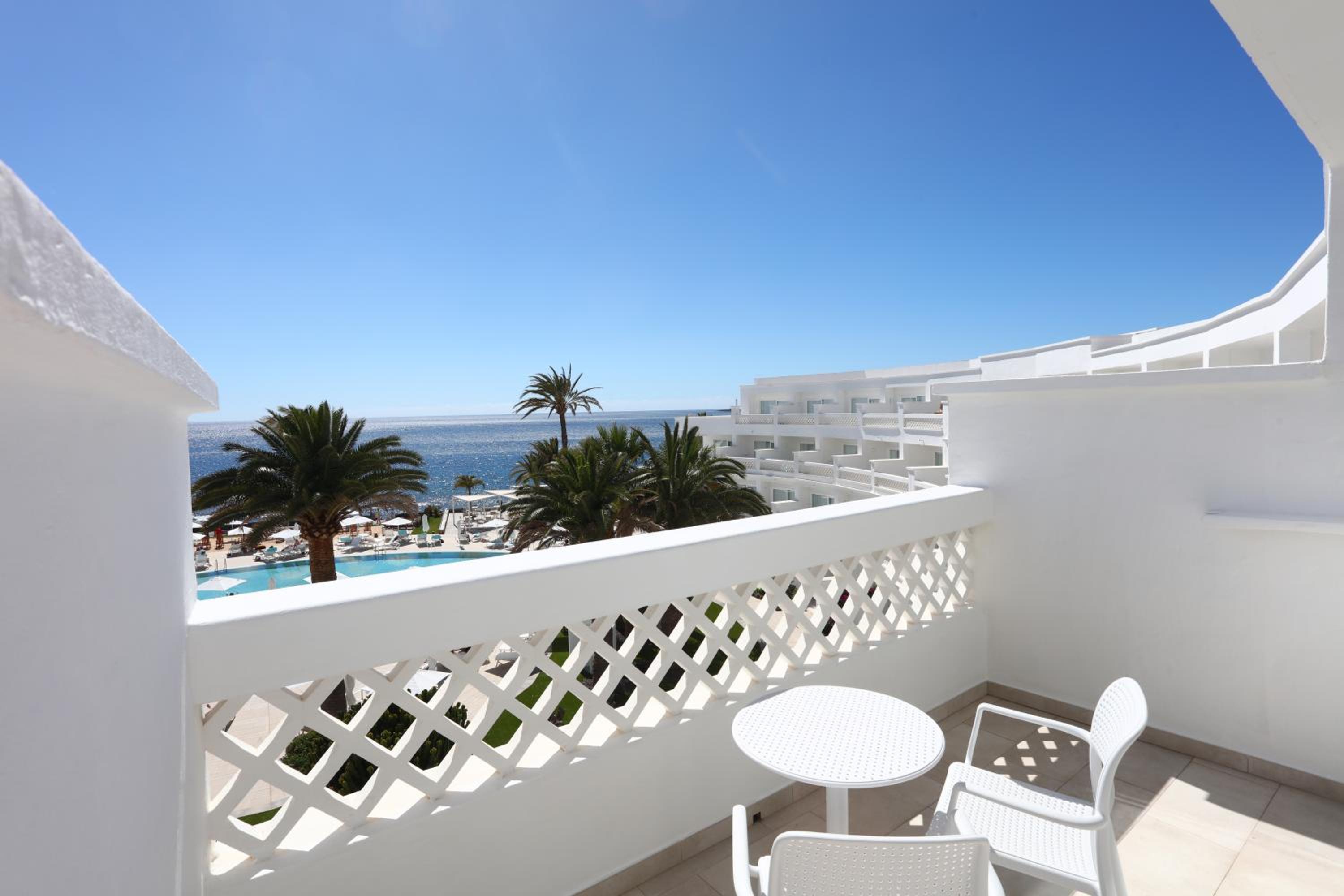 balcony with a table and chairs overlooking the ocean?