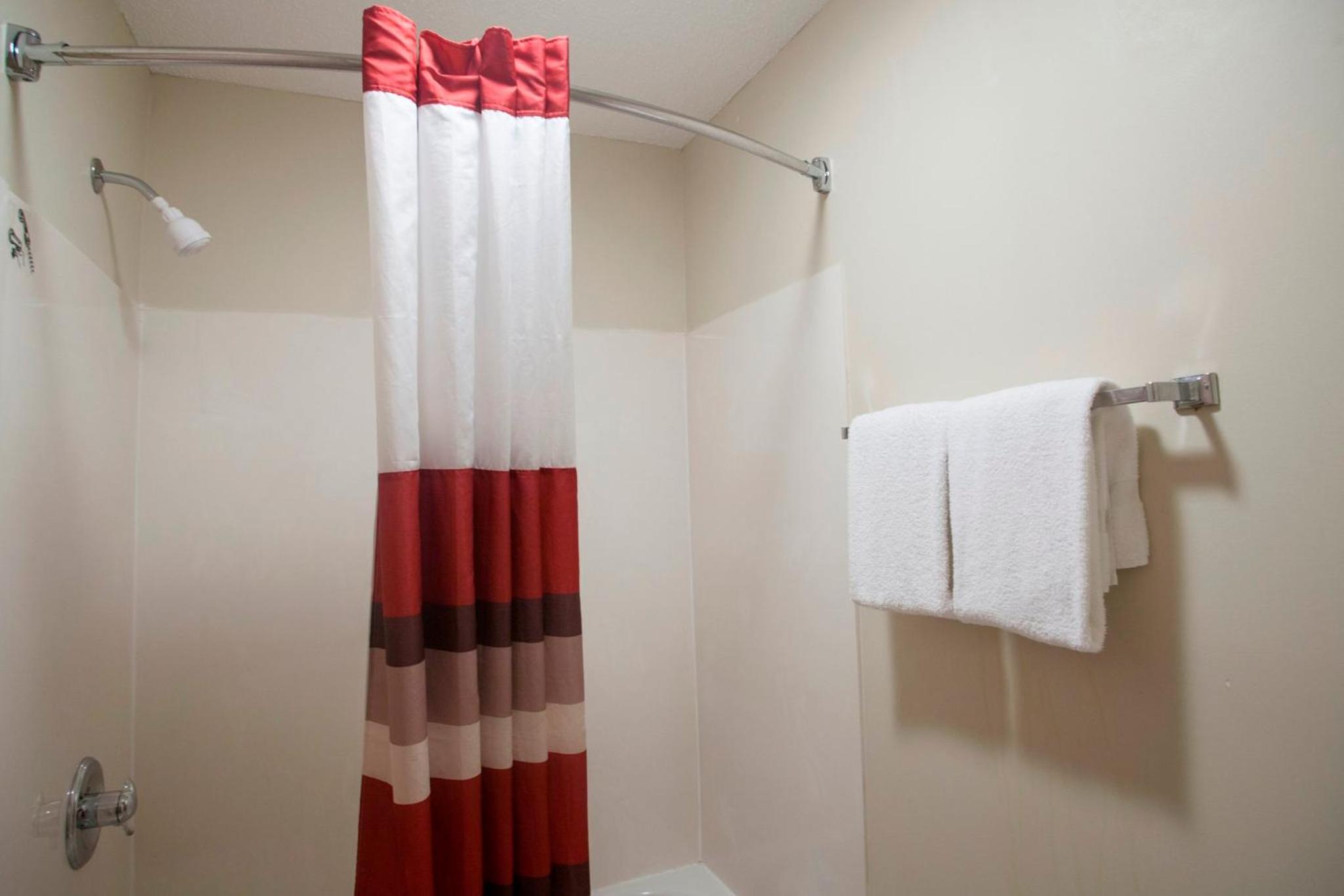 bathroom with a red and white shower curtain in it