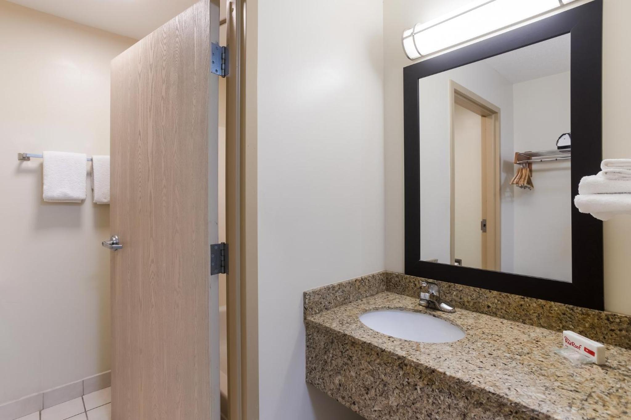 bathroom with a marble counter top and a large mirror