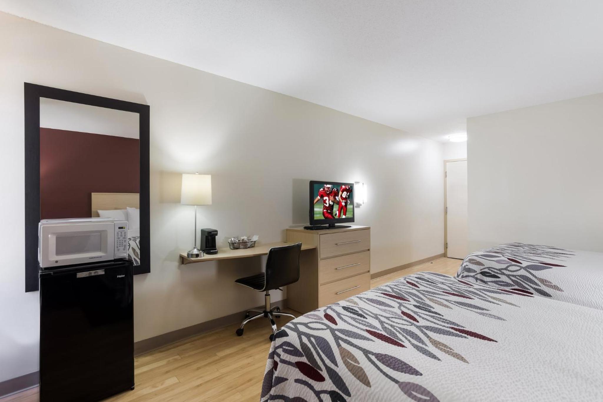 hotel room with a bed, desk, and television