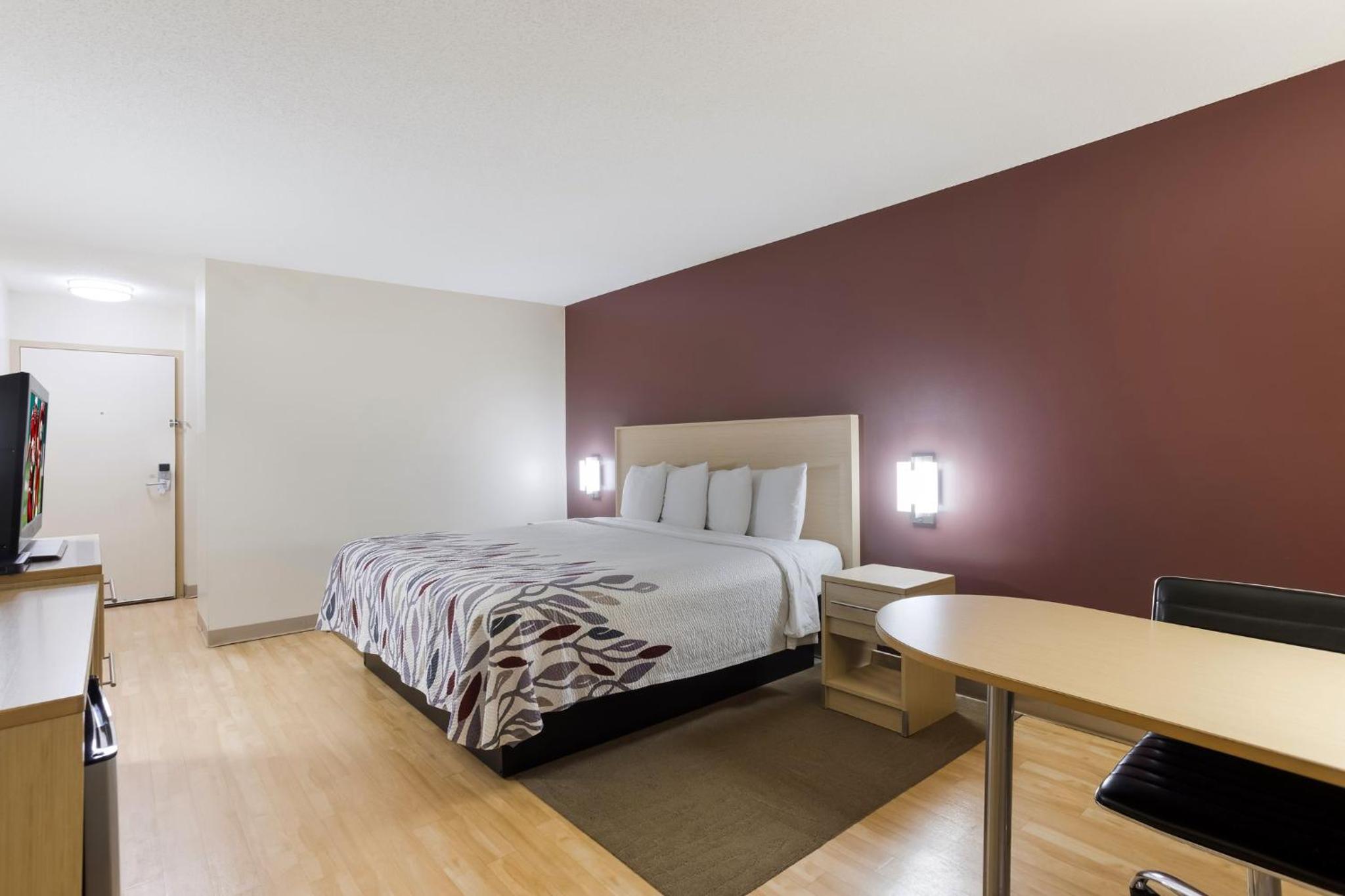 hotel room with a bed, desk, and television
