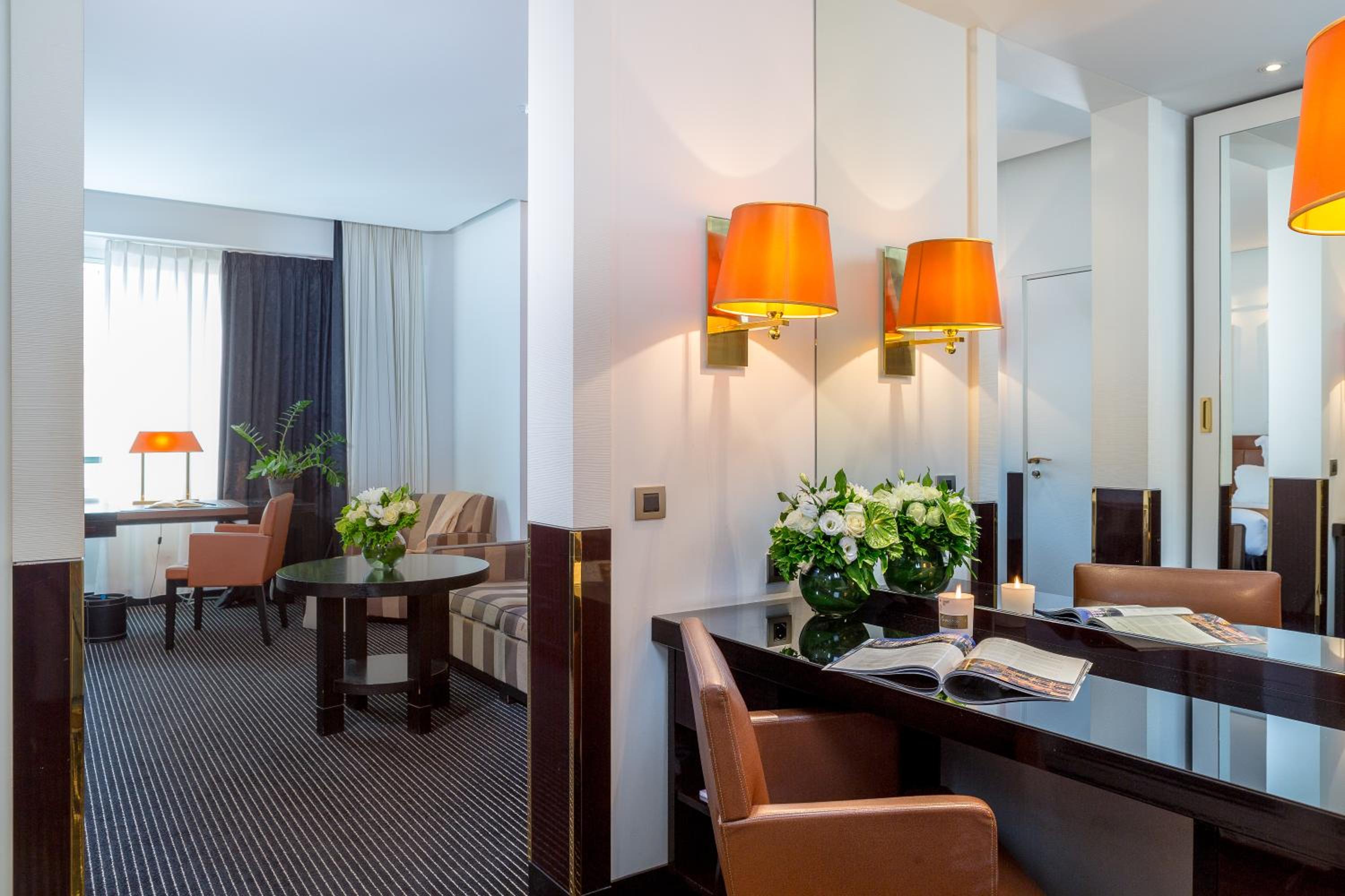 hotel room with a desk, chairs and a mirror