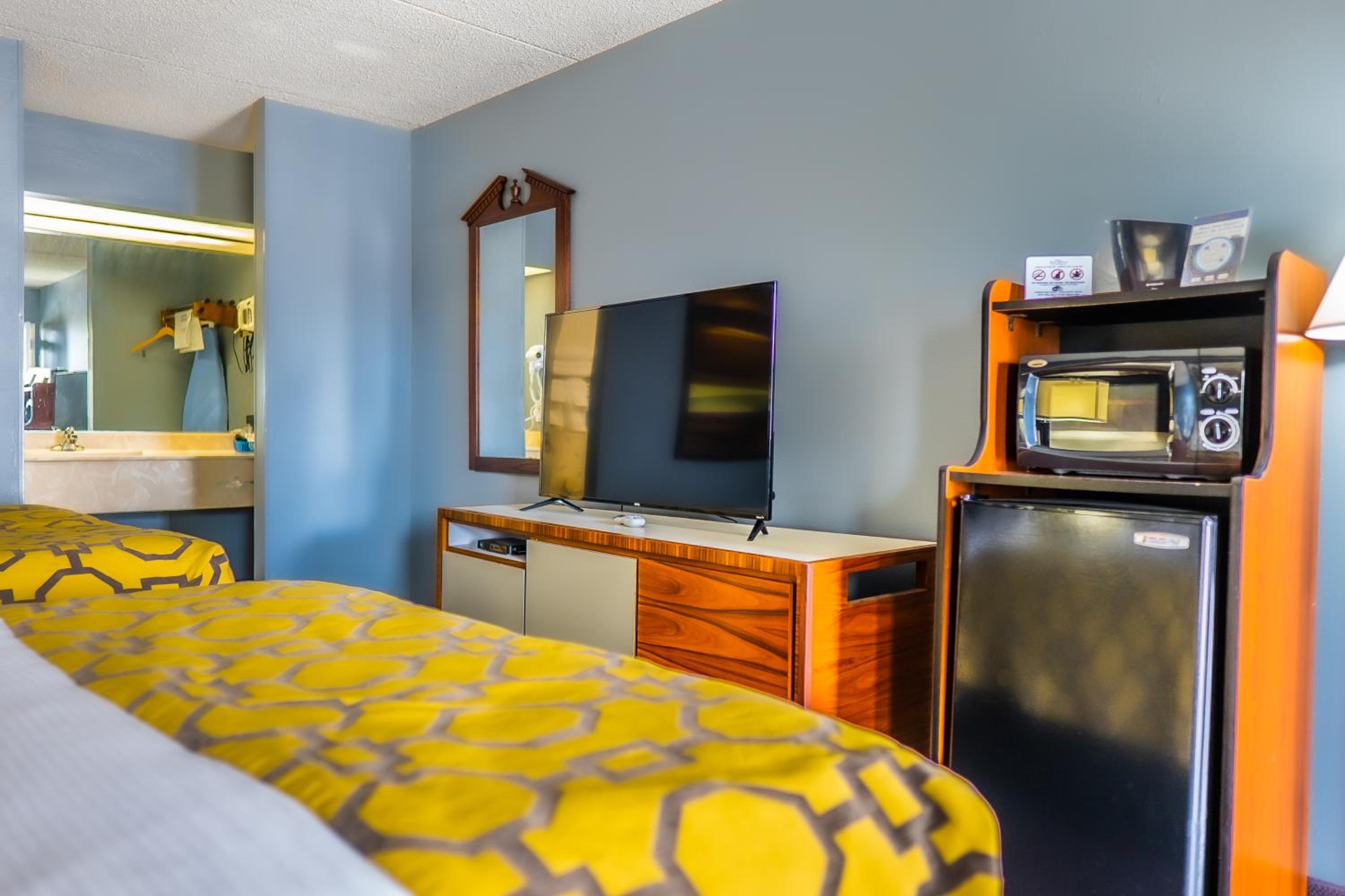 hotel room with a television, microwave, and bed