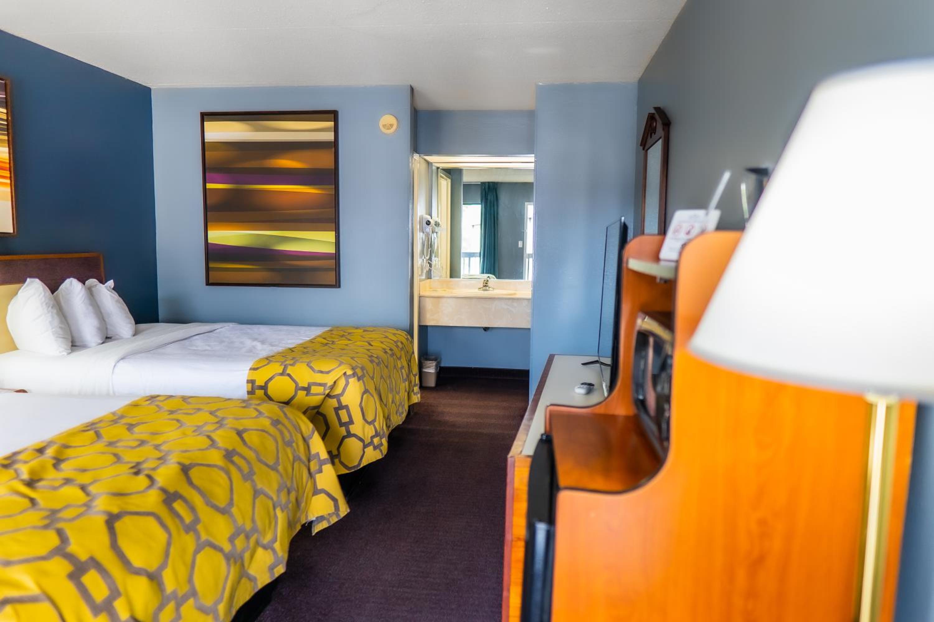 hotel room with two beds and a painting on the wall