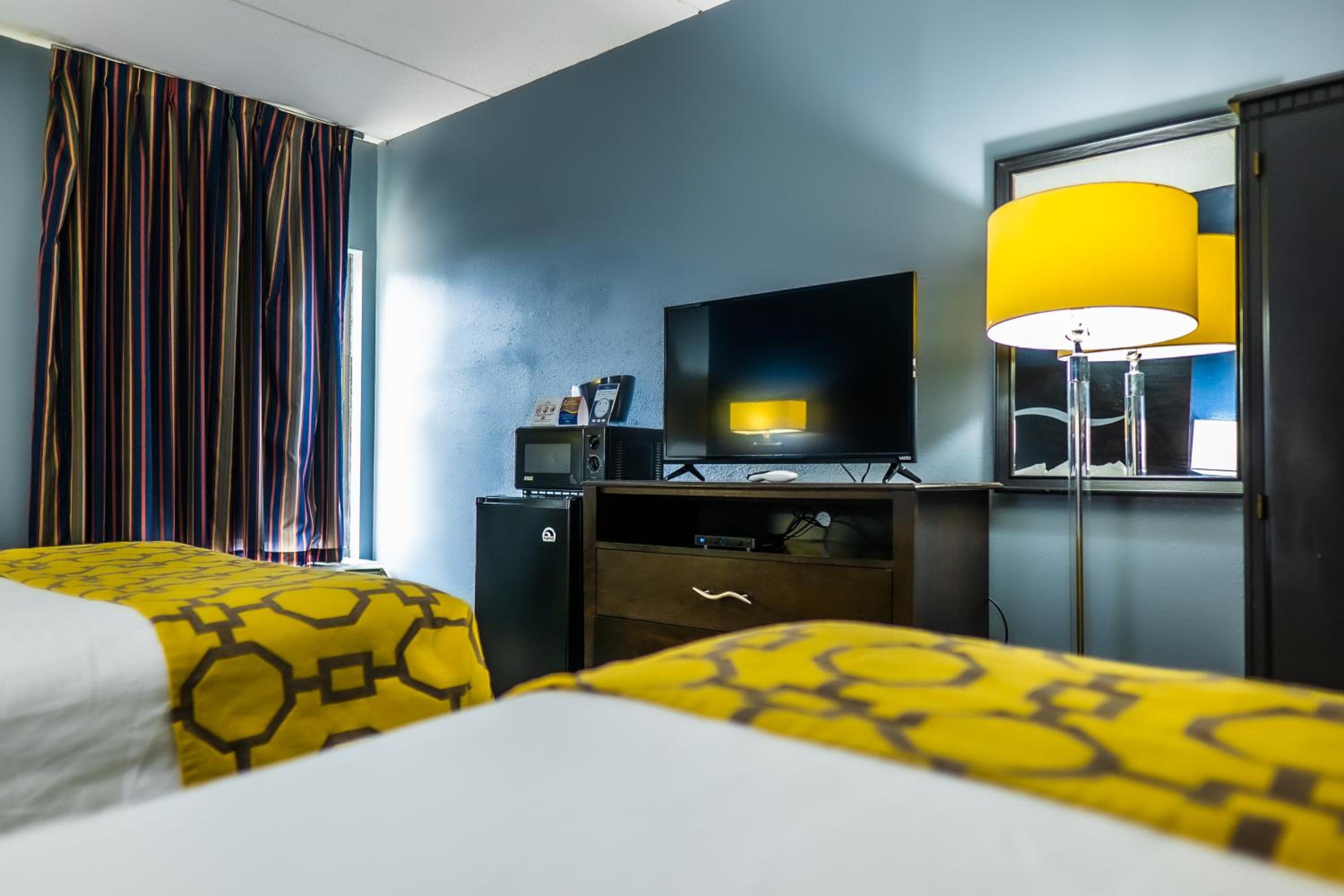 hotel room with two beds and a flat screen tv