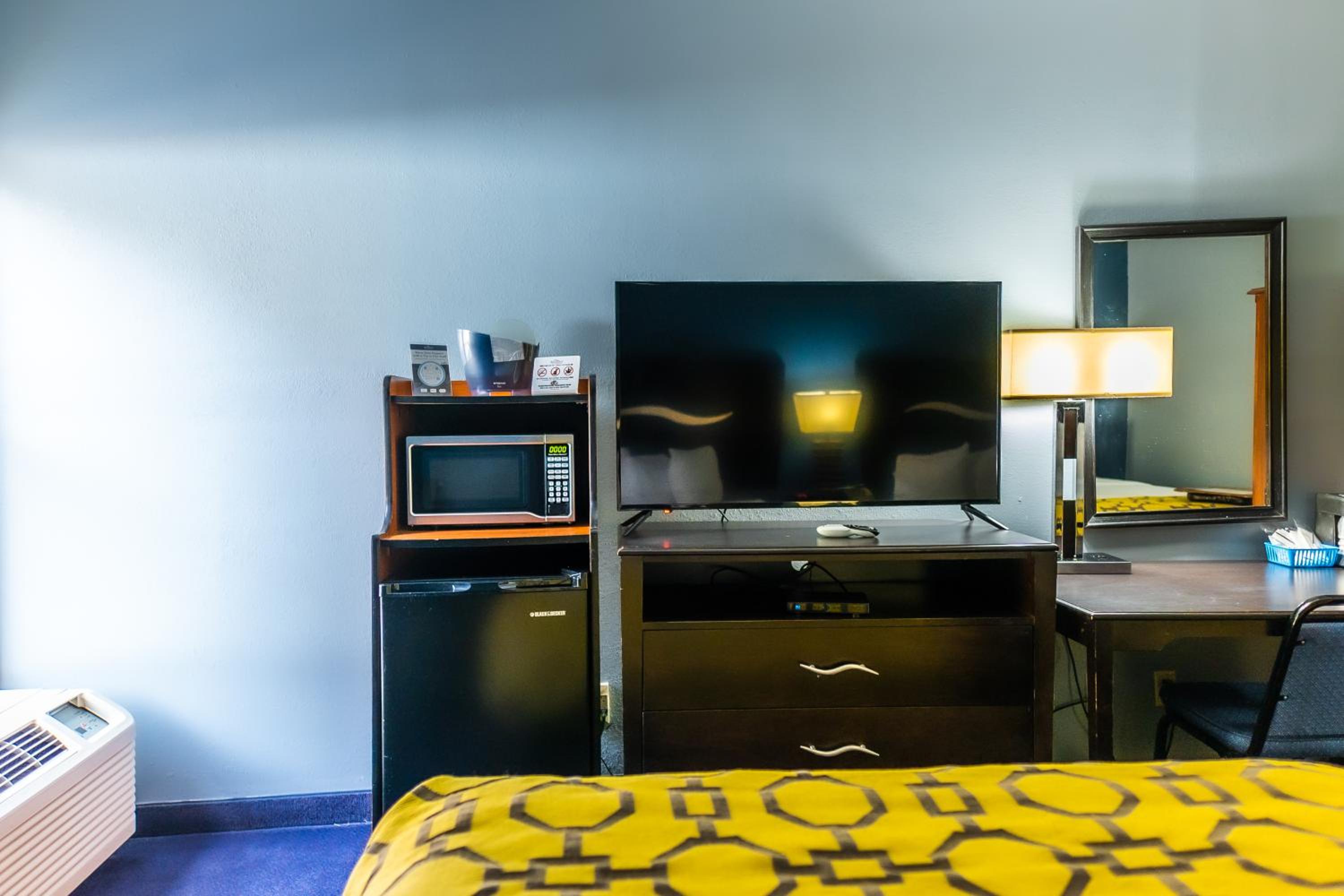hotel room with a bed, desk, and television