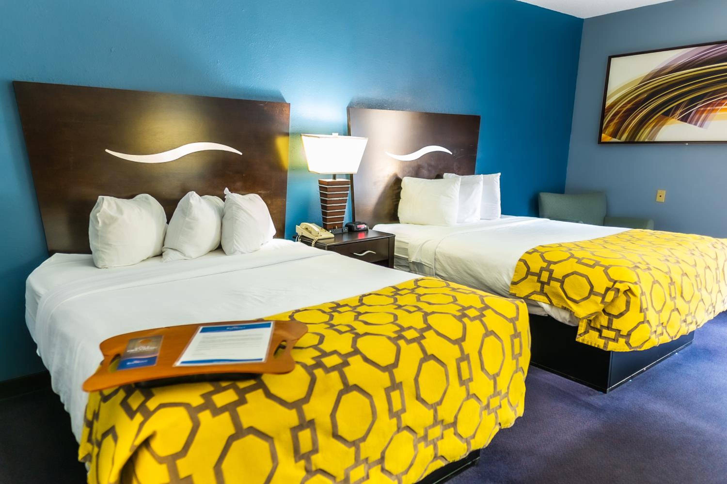 hotel room with two beds and a painting on the wall