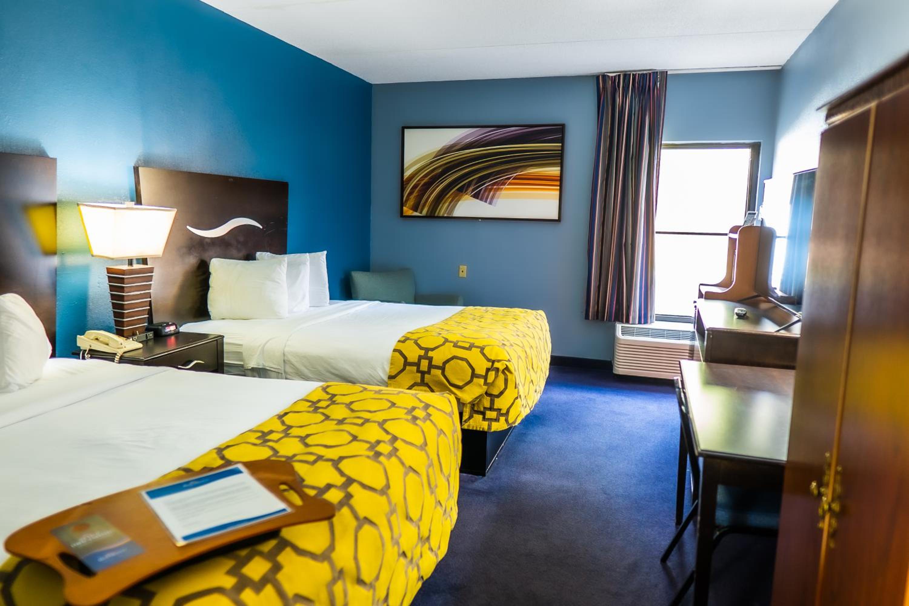hotel room with two beds and a desk in it