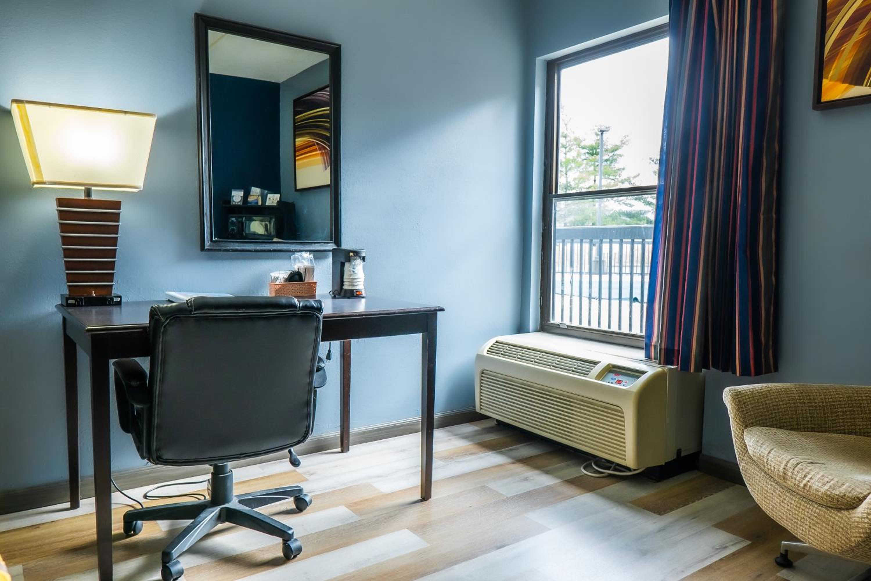 room with a desk, chair, and air conditioner