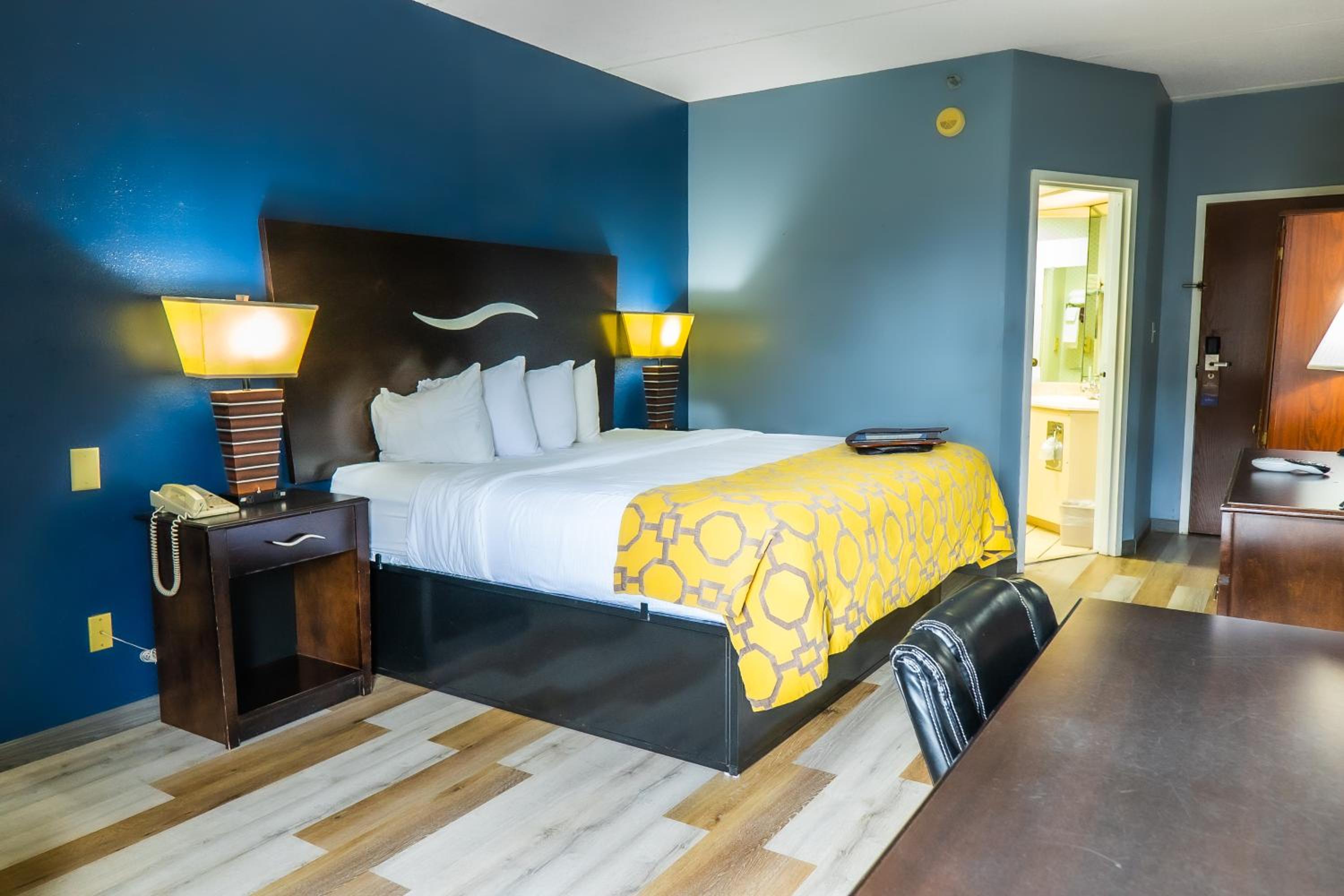hotel room with a bed, desk, and chair