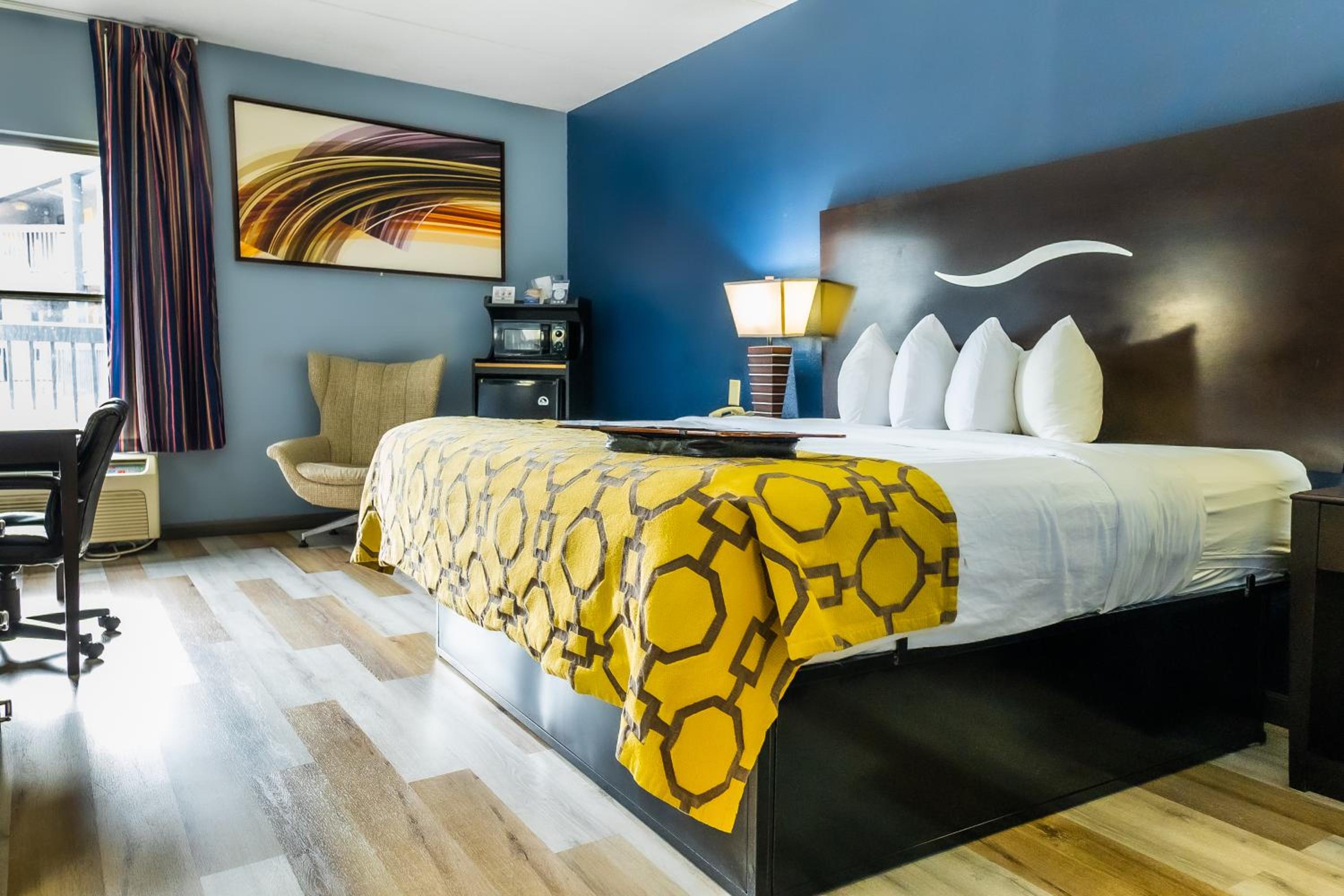 hotel room with a bed, desk, and chair