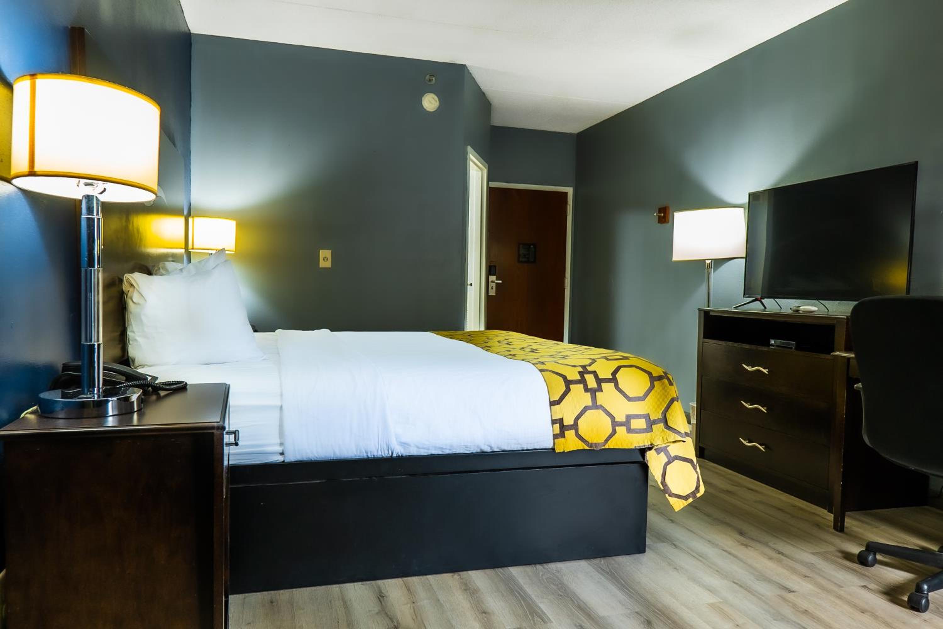 hotel room with a bed, desk, and television