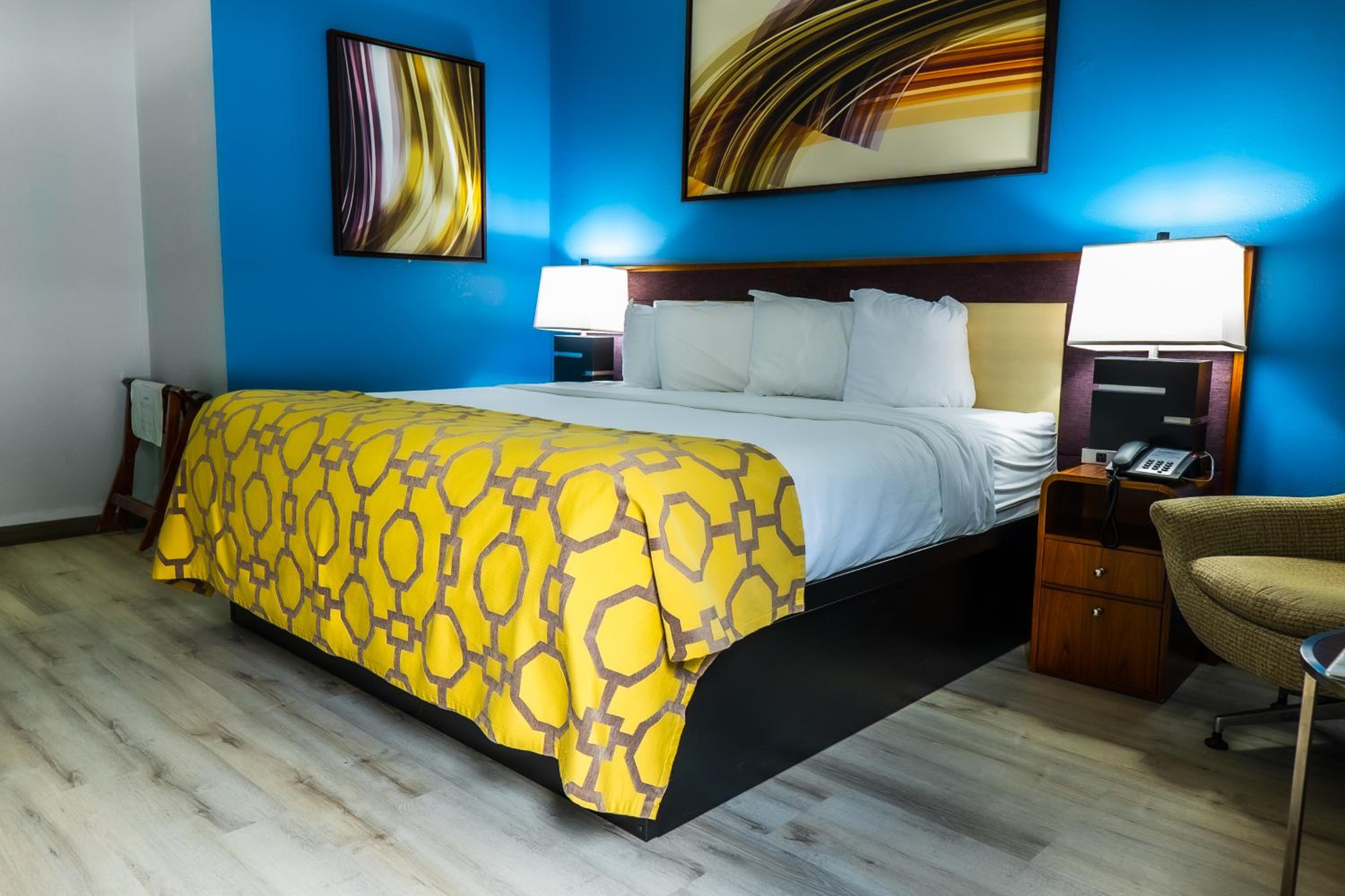 hotel room with blue walls and a yellow bedspread