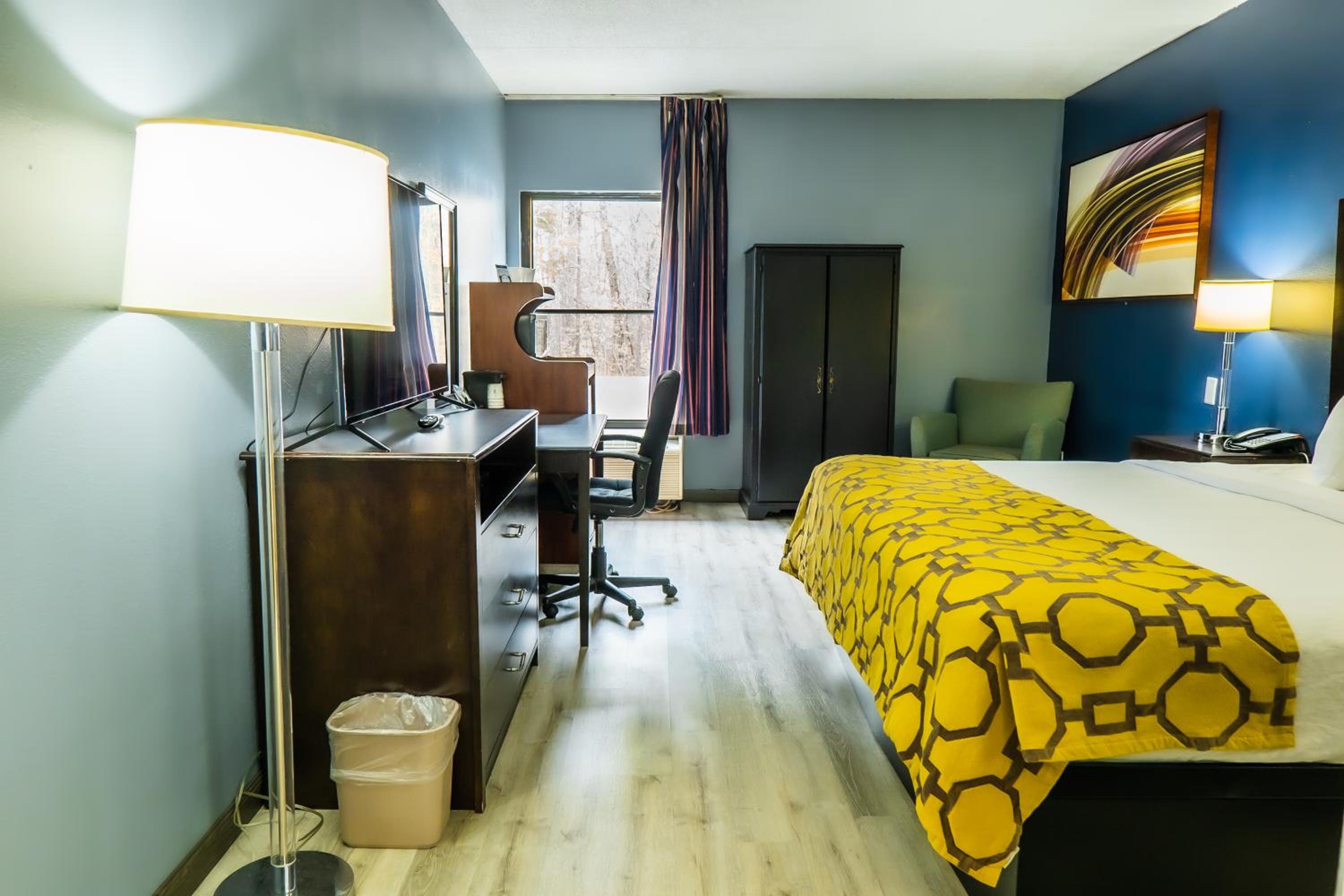 hotel room with a bed, desk, and television