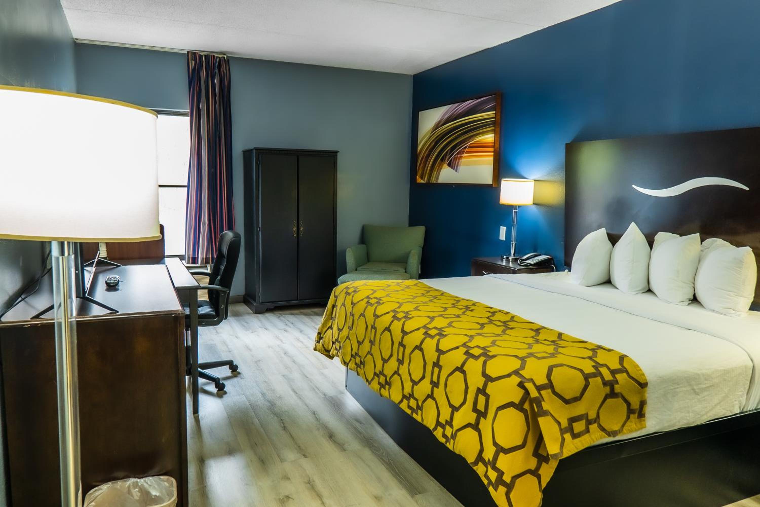 hotel room with a bed, desk, and chair