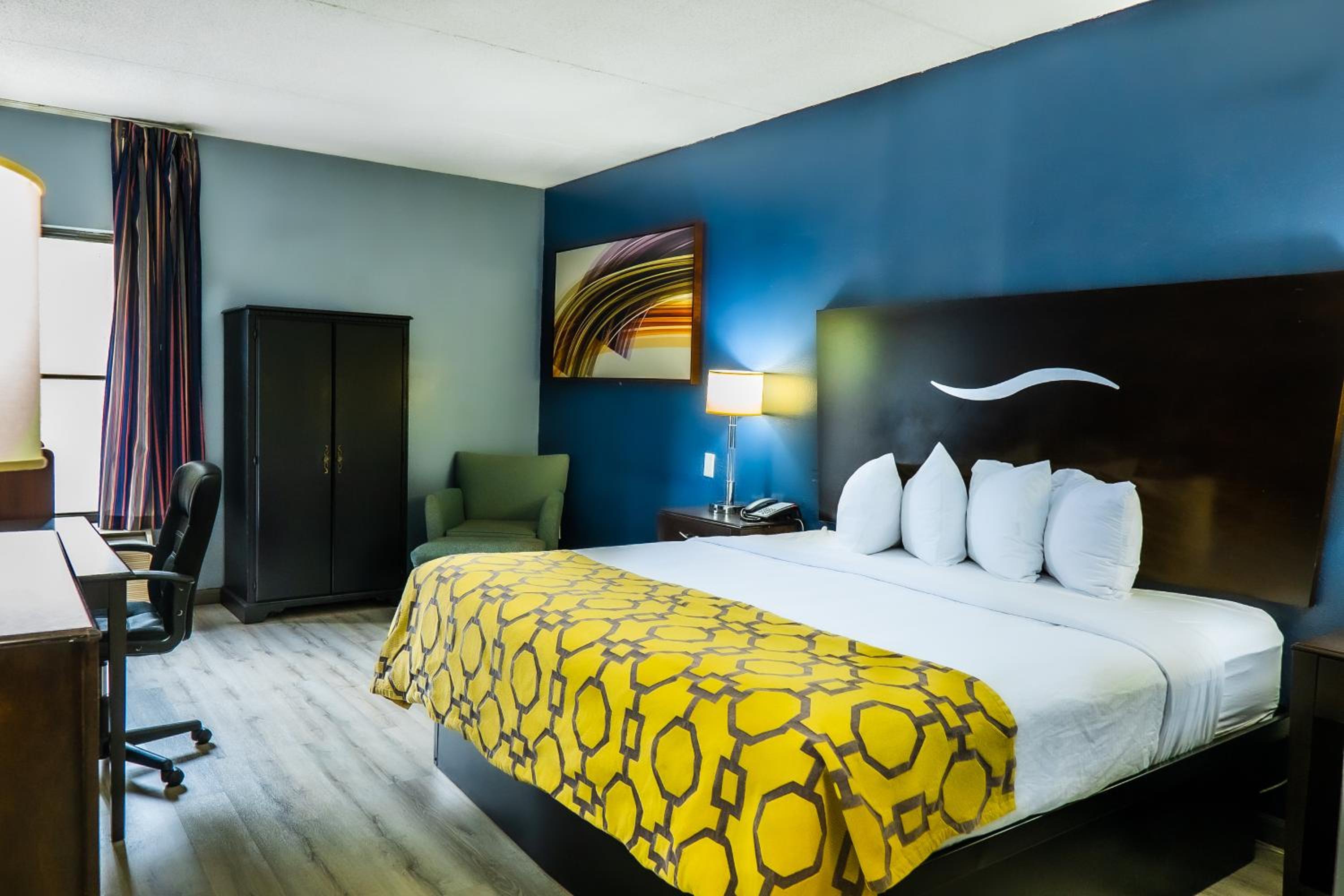 hotel room with blue walls and a yellow bedspread