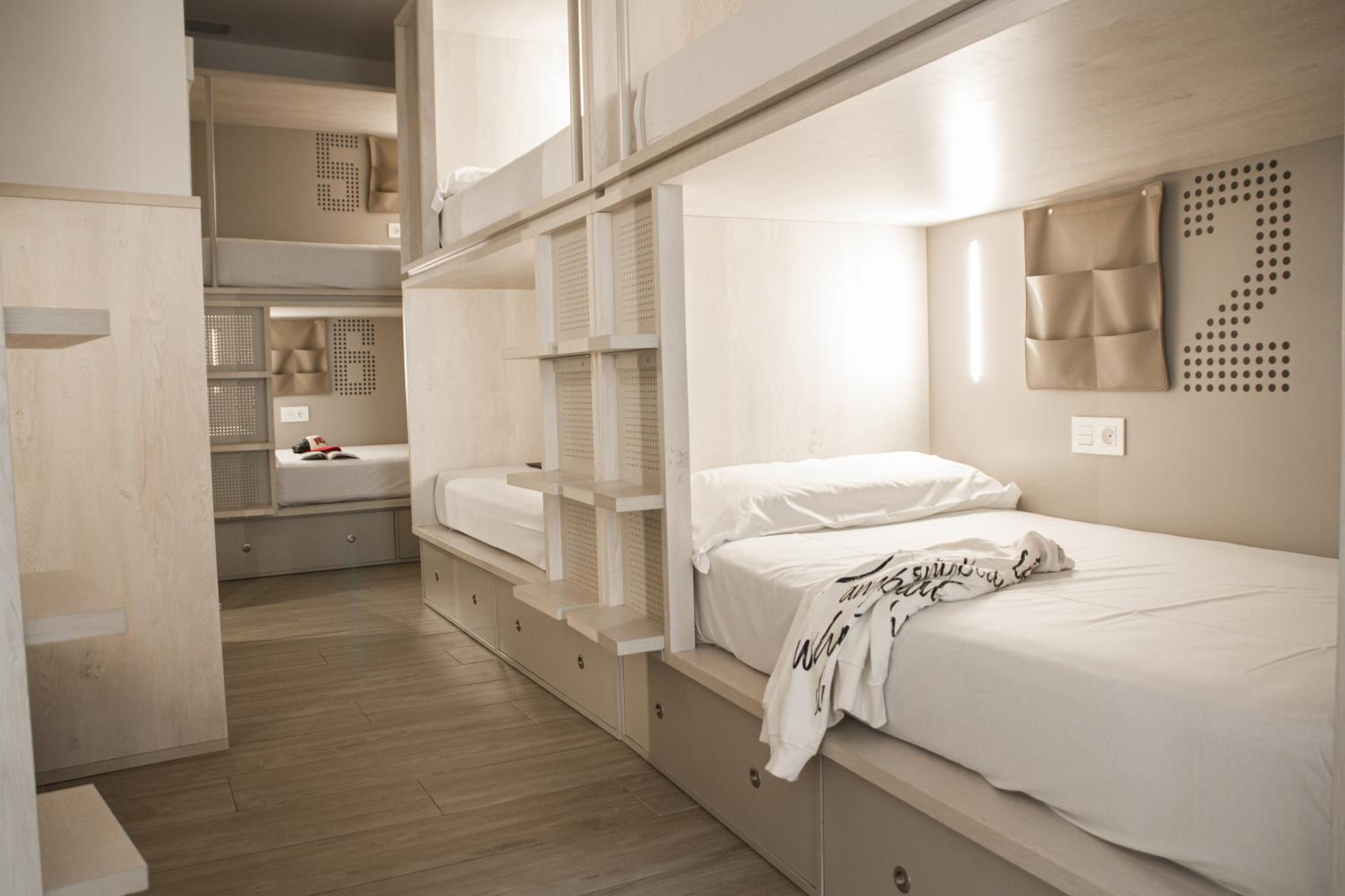 Cama en dormitorio compartido mixto de 8 camas con baño privado.