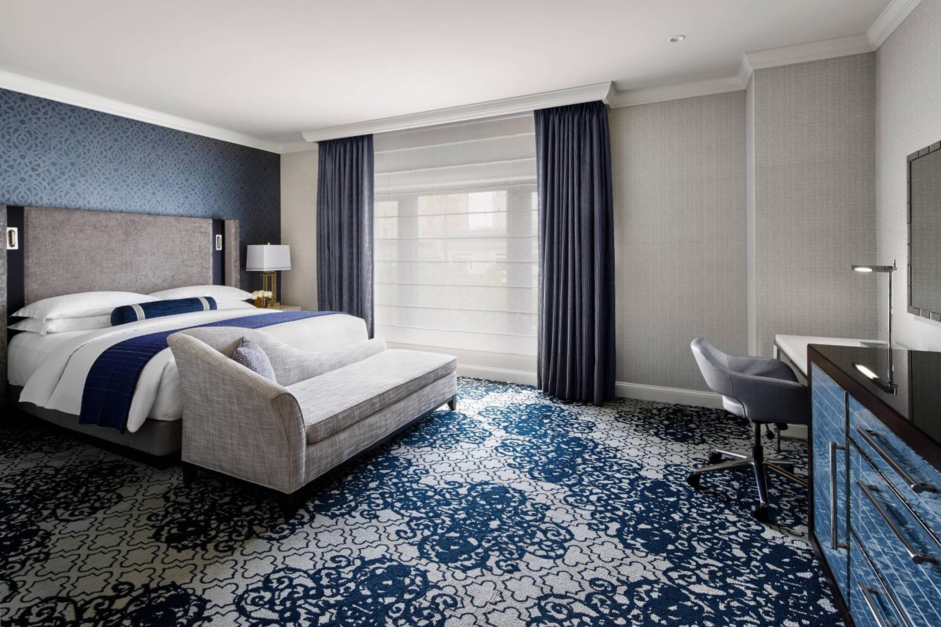 blue and white hotel room with a king size bed