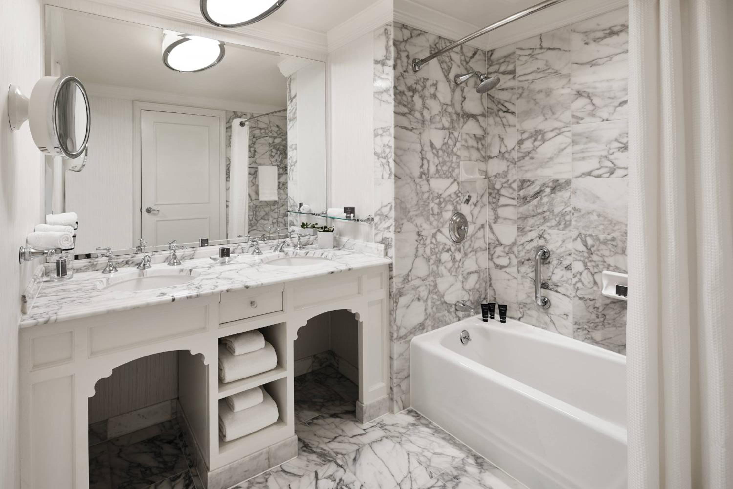 marbled bathroom with two sinks and a bathtub