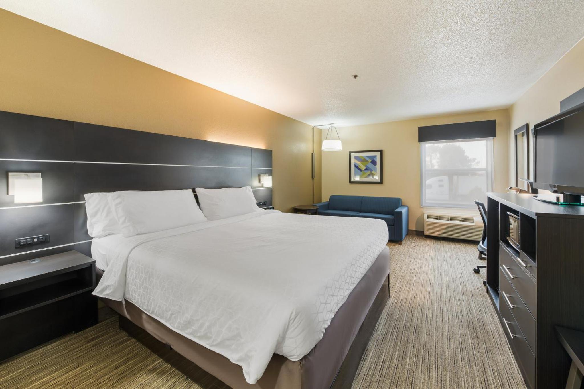 hotel room with a king bed and a flat screen tv