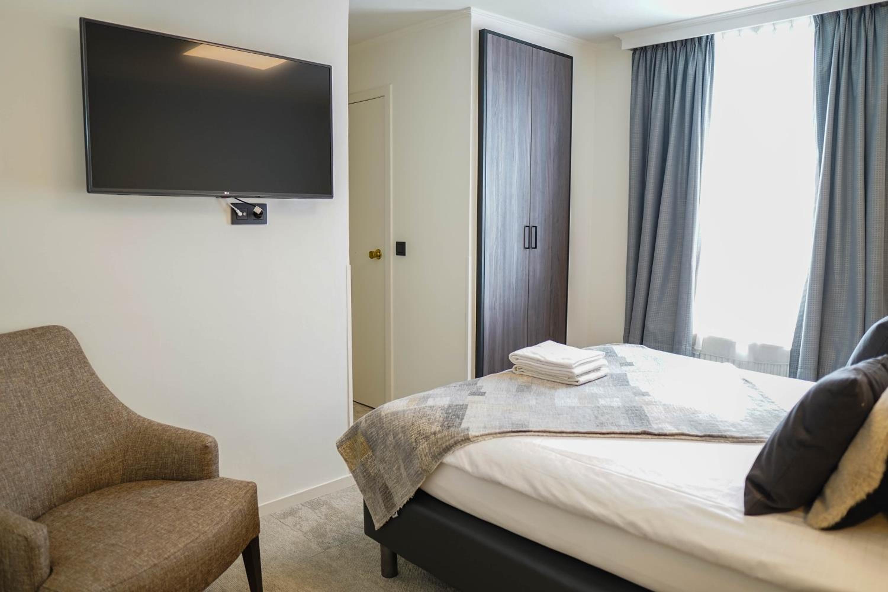 bedroom with a flat screen tv mounted above the bed